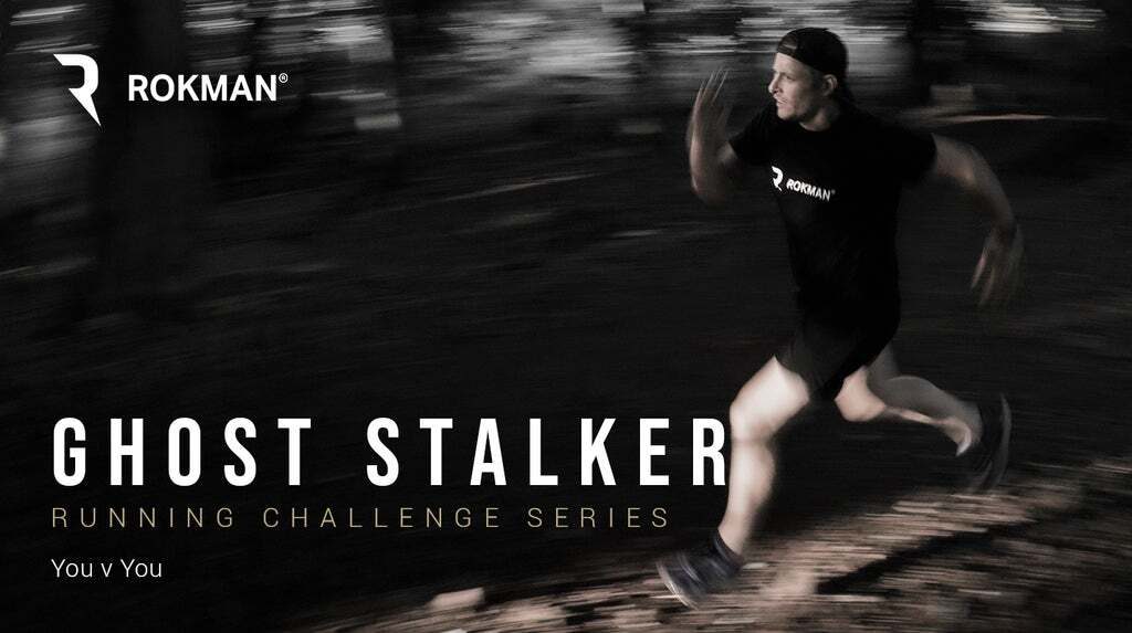 A man in athletic wear is running through a dark, wooded area at night. The image has motion blur, emphasizing his speed. The text overlay reads "ROKMAN Ghost Stalker Running Challenge Series - You v You." The ROKMAN logo is visible in the top left corner.