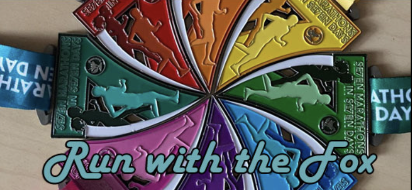 A colorful arrangement of medals forms a pinwheel shape, each medal featuring a silhouette of a running figure. The medals have various bright colors and read "Run with the Fox." The ribbons attached to the medals are visible at the top and bottom edges.