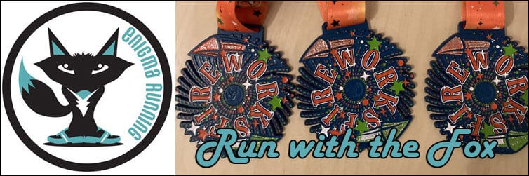 A round logo on the left shows a cartoon fox with blue accents within a white circle, labeled "Enigma Running." To the right, three colorful medals display a fireworks design and the text "Run with the Fox." The background is light tan wood.