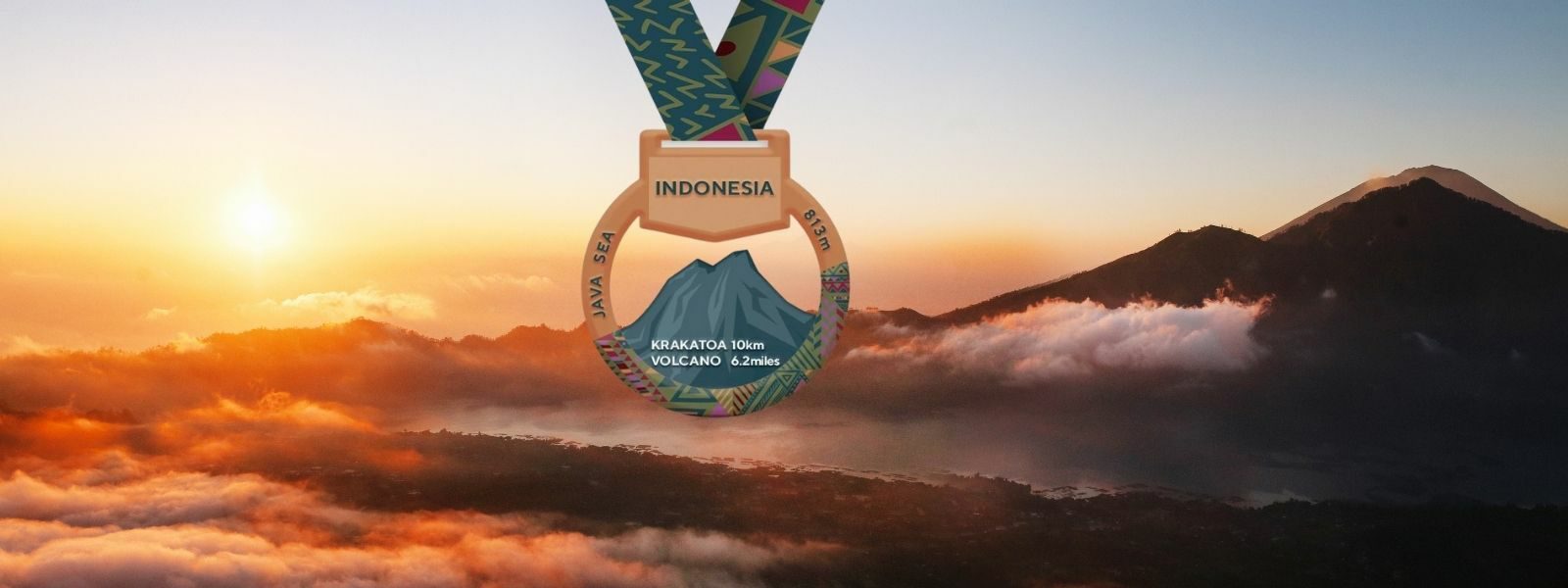 A medal featuring a mountain landscape design and the word "INDONESIA" at the top hangs against a background of a scenic sunrise or sunset over a mountainous region, with clouds and a volcano peak visible. The words "KRAKATOA ULTRA VOLCANO 2022" are inscribed on the medal.