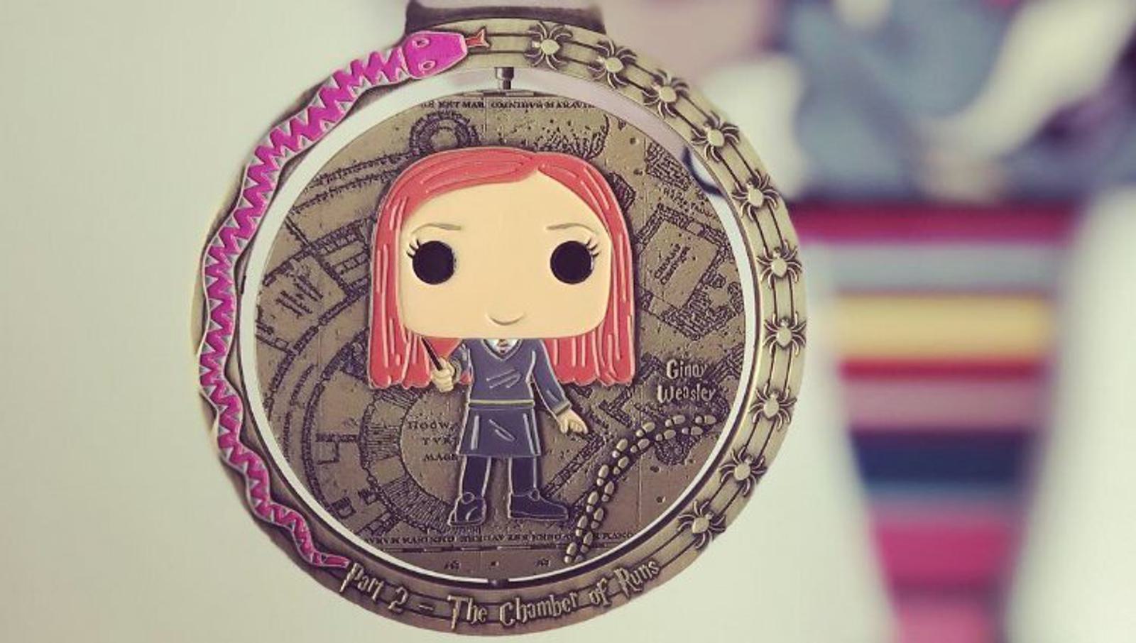 A collectible medal featuring a stylized figurine of a character with red hair and a wand, standing against a detailed background with map-like elements. A pink serpent encircles the edge of the medal, which is inscribed with "Chapter 17: The Chamber of Secrets.