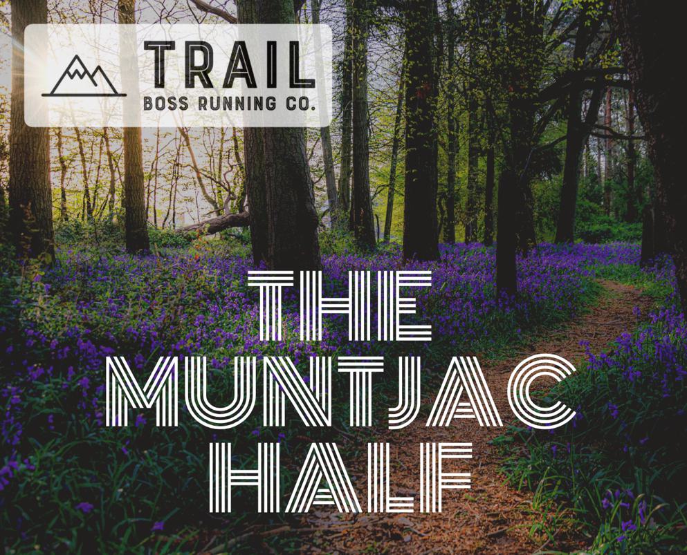 A scenic forest trail running through lush greenery and blooming purple flowers, with text overlaid that reads "Trail Boss Running Co. The Muntjac Half." The tree canopy filters sunlight onto the path, creating a serene atmosphere.