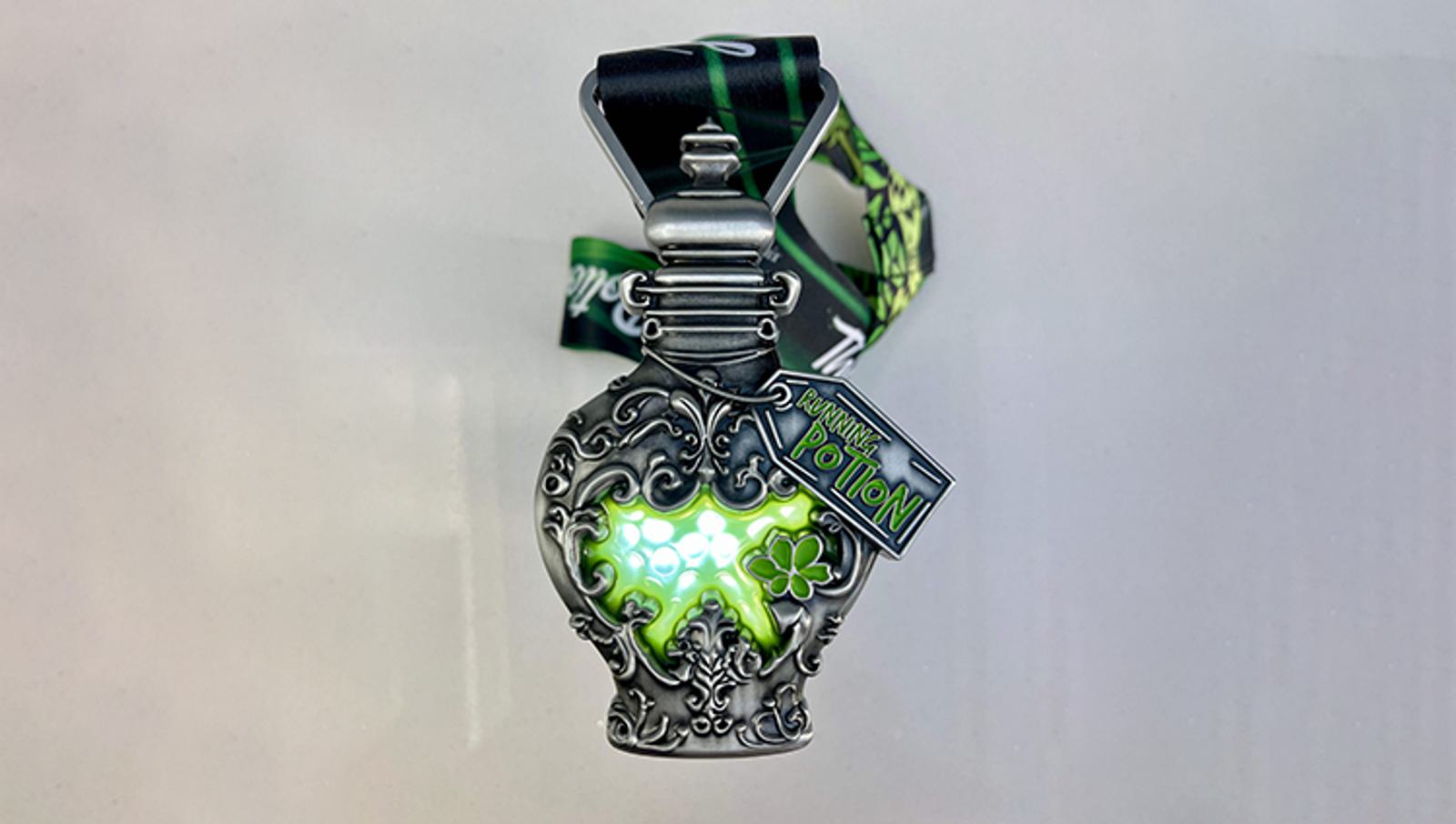 A decorative potion bottle-shaped medal with ornate silver detailing and a glowing green center. It hangs from a green and black ribbon, labeled "Running Universal Trolls Virtual Potion.