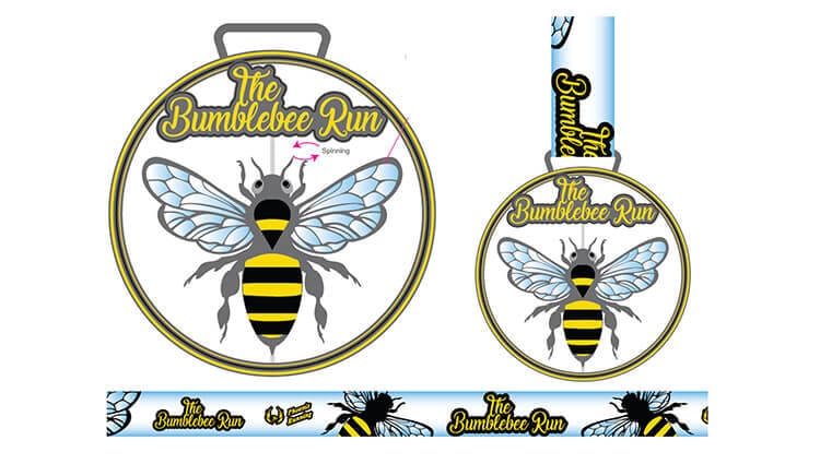 A medal and ribbon for "The Bumblebee Run" featuring a large cartoon bumblebee with blue wings on a circular medal, and the event name in yellow script above the bee. The ribbon has repeating bee and event name designs.