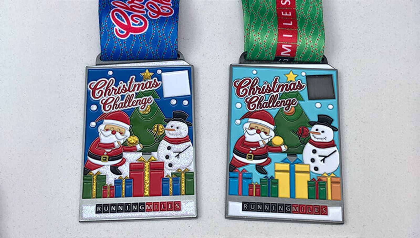 Two colorful Christmas Challenge medals featuring Santa Claus, a snowman, and gifts. The medals are designed with festive colors, one with a blue ribbon and the other with a green ribbon, both reading "Running Miles.
