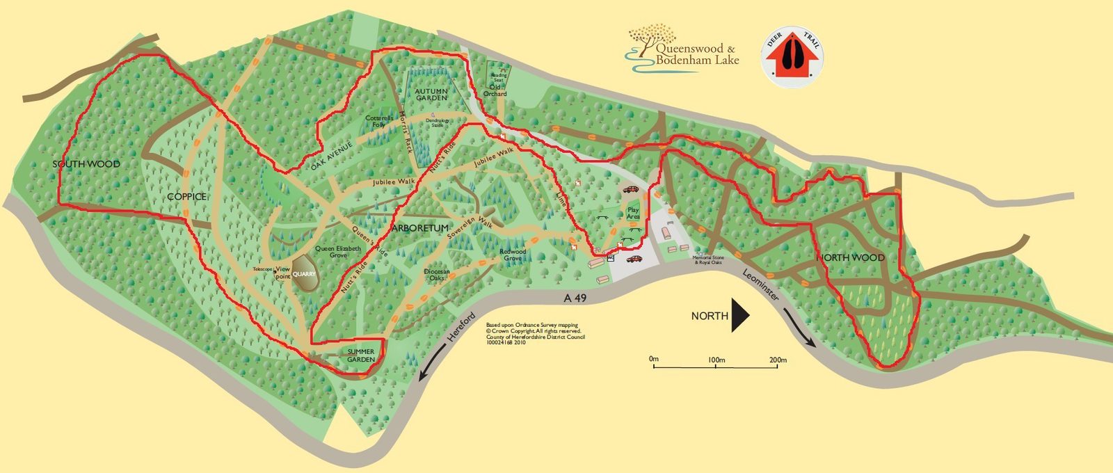 A map of Queenswood Country Park showcasing the surrounding woodland trails. The map features marked trails in red, with paths winding through Southwood and Northwood. Amenities such as a picnic area, parking, and visitor center are also indicated.
