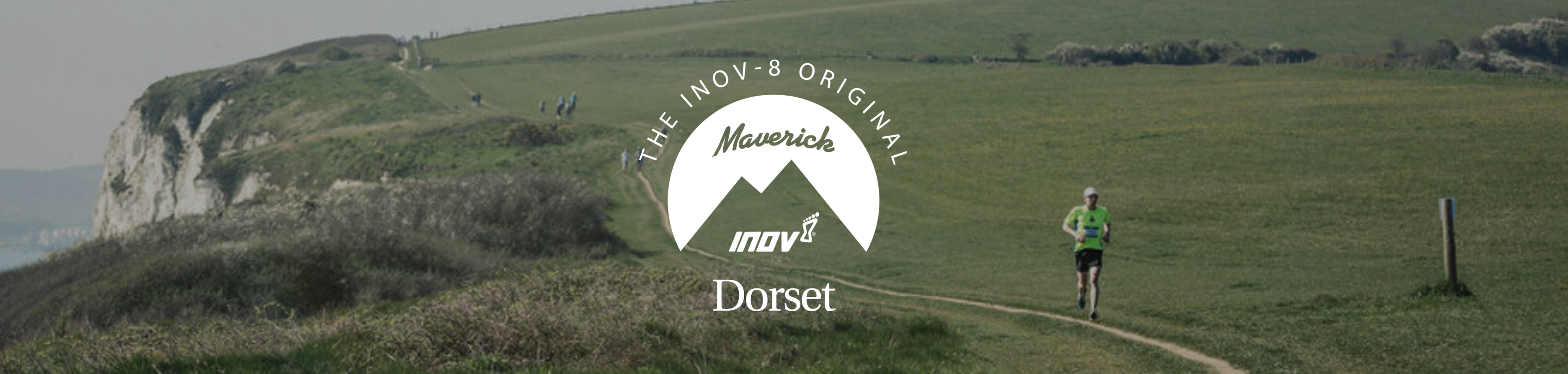 A runner wearing a lime-green shirt and black shorts jogs along a dirt path in a grassy, hilly landscape in Dorset. The scene is part of an event by The Maverick Inov-8 Original, with the logo prominently displayed in the center of the image.