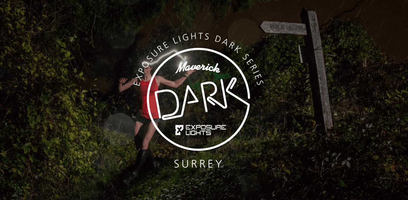 A person runs through a dark, wooded trail illuminated by a headlamp, with a wooden signpost in the background. The text overlay reads "Maverick DARK: Exposure Lights Dark Series - Surrey" with logos for Exposure Lights and Maverick.