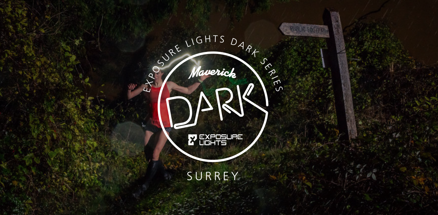 A person runs through a dark, wooded trail illuminated by a headlamp, with a wooden signpost in the background. The text overlay reads "Maverick DARK: Exposure Lights Dark Series - Surrey" with logos for Exposure Lights and Maverick.