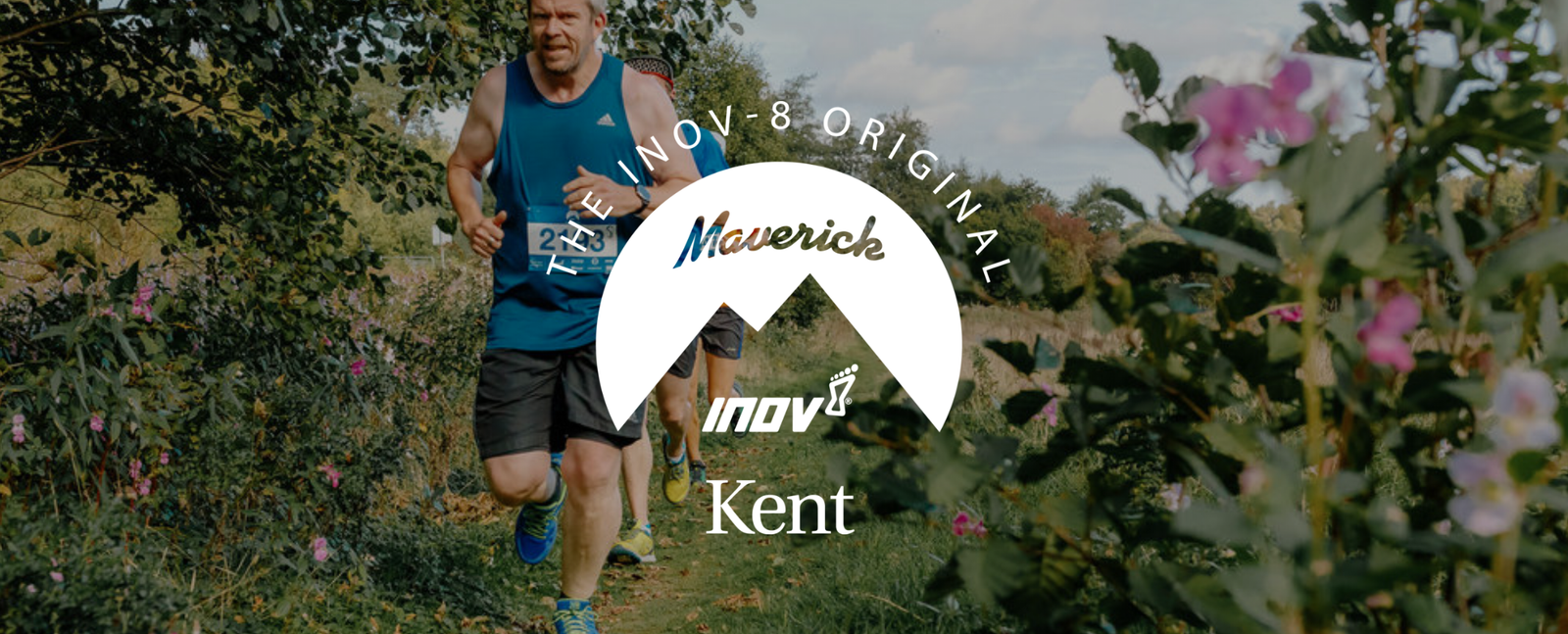 Two people are running on a grassy and flower-lined trail. The central overlay includes circular text "The INOV-8 Original" at the top, "Maverick" in the middle over a mountain-like graphic, "inov-8" below it, and "Kent" at the bottom.