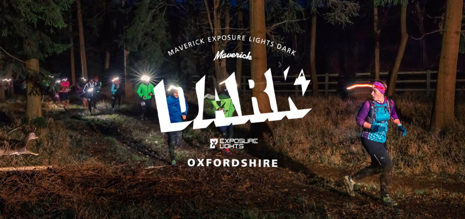 A group of trail runners with headlamps running through a forest at night. A large logo in the center reads "MAVERICK EXPOSURE LIGHTS DARK" and "OXFORDSHIRE" beneath it, promoting the event. Trees and underbrush are visible in the background.