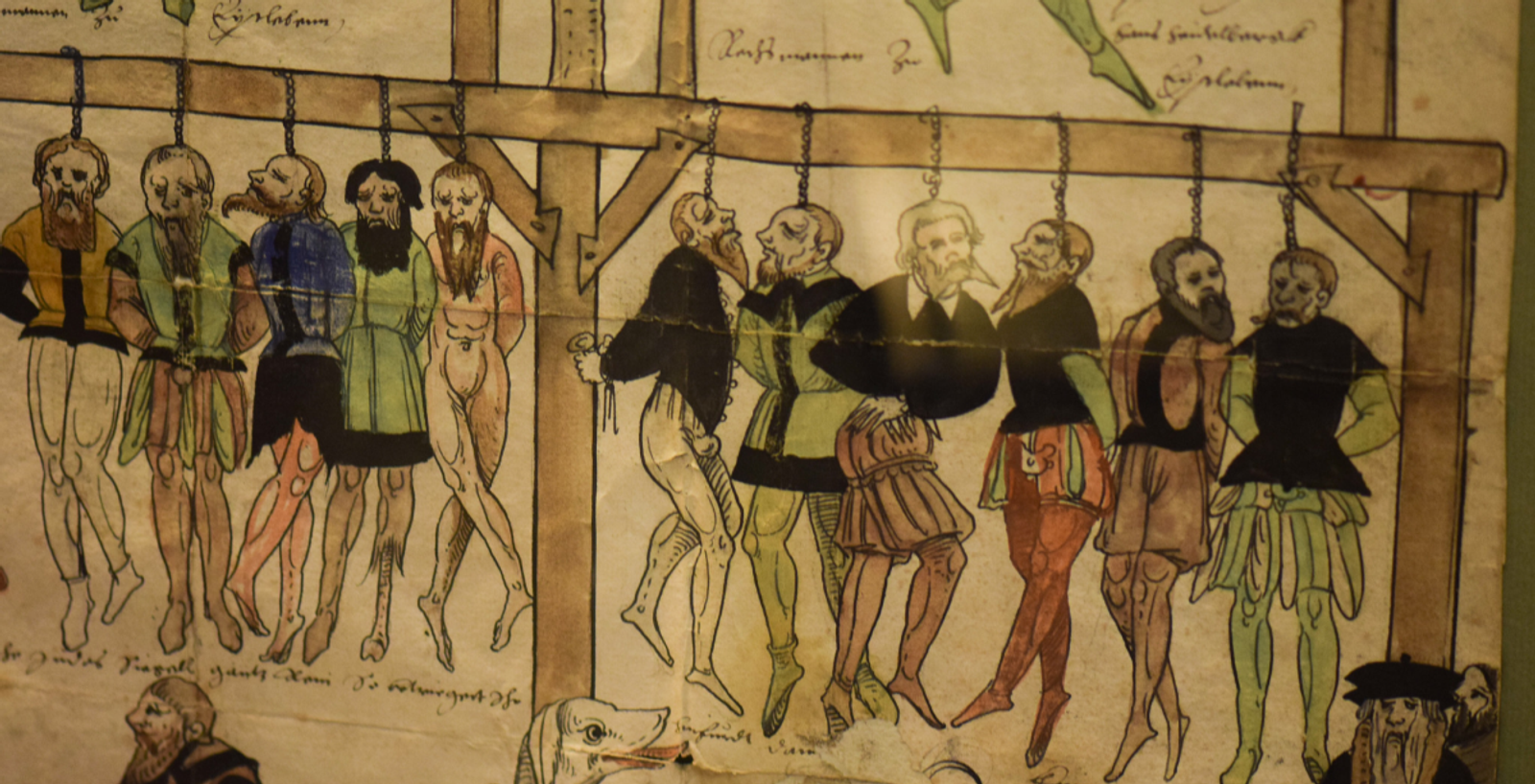 A detailed illustration from medieval times depicts several men, some in colorful garments, hanging from a wooden gallows. The expressions and postures convey a scene of execution. The artwork is aged with faded colors and sepia-toned paper.