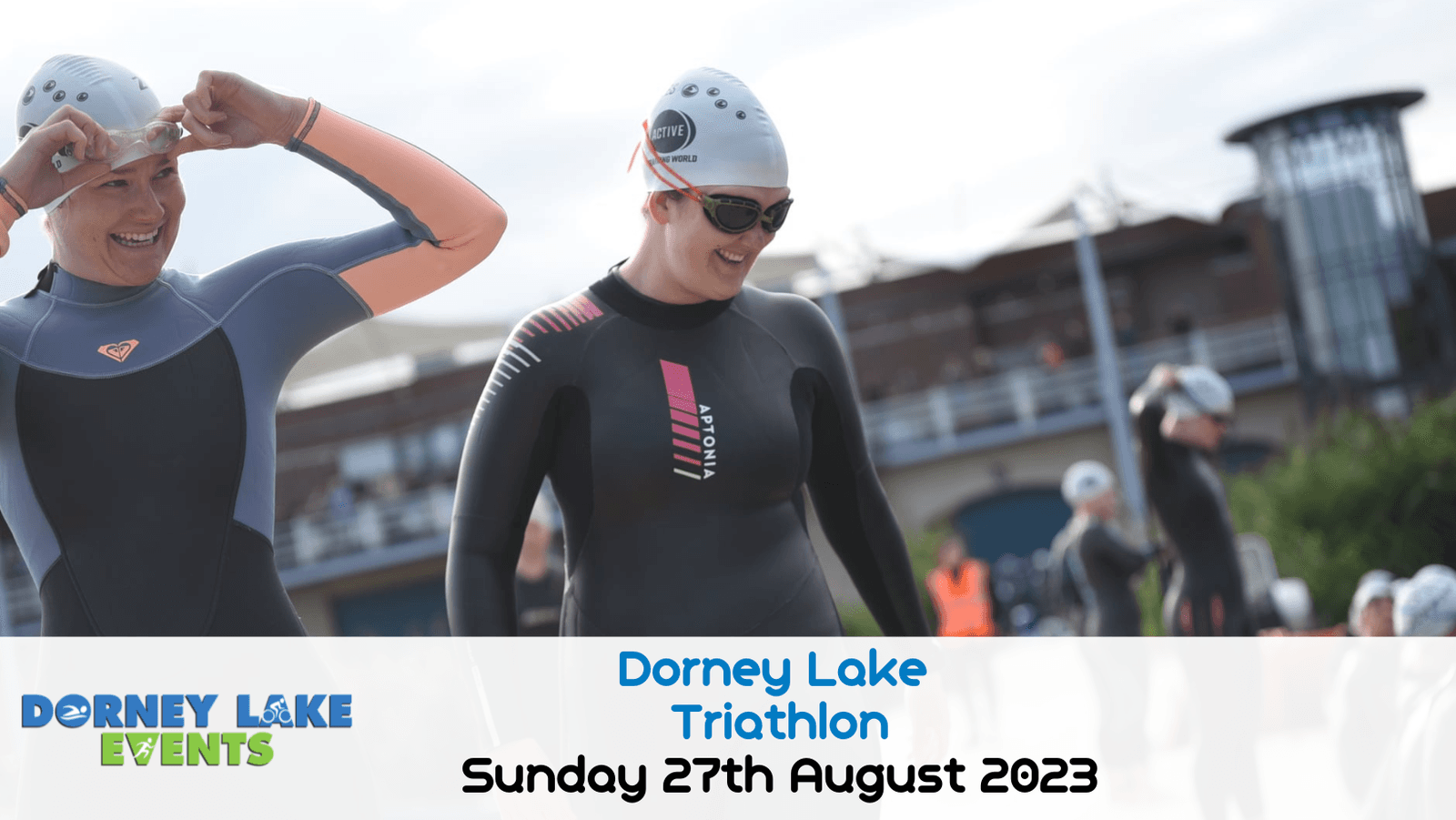 Participants in wetsuits and swim caps prepare for a triathlon at Dorney Lake. A banner at the bottom reads "Dorney Lake Events: Dorney Lake Triathlon, Sunday 27th August 2023." The background shows a large building and other participants getting ready.