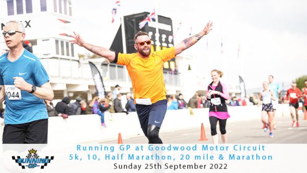 A man in a bright orange shirt and sunglasses enthusiastically spreads his arms while running on a race track during the Running GP at Goodwood Motor Circuit. Other participants are also visible, along with race banners and the event details on the image.