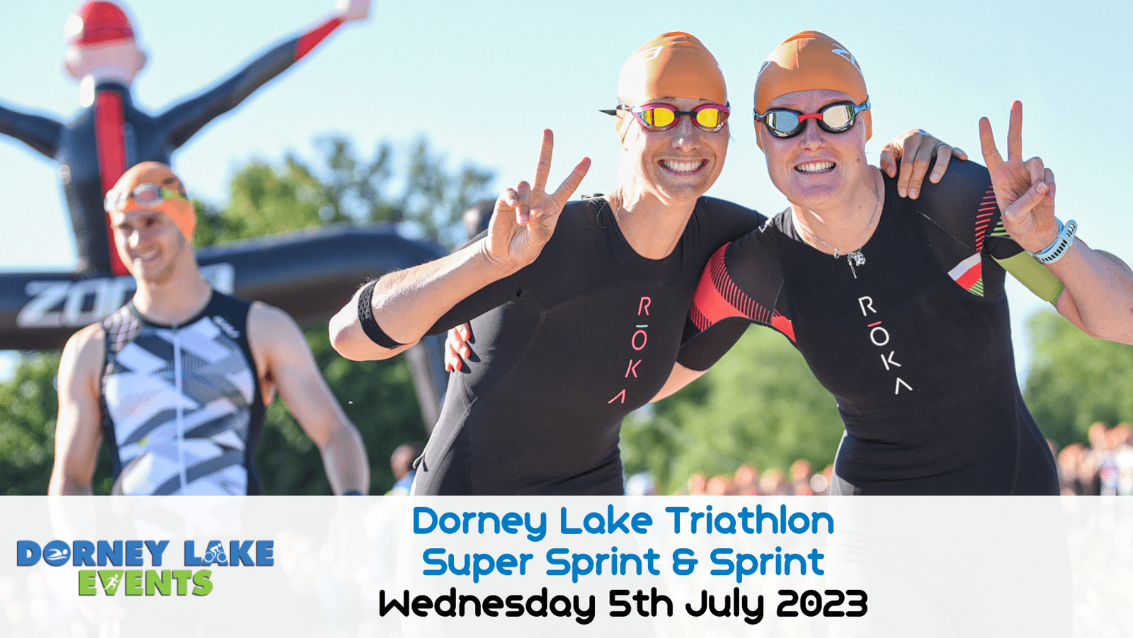 Two triathletes, wearing swimsuits and goggles, smile and flash peace signs at the Dorney Lake Triathlon. The event details, "Dorney Lake Triathlon Super Sprint & Sprint, Wednesday 5th July 2023," are written at the bottom over a white banner.