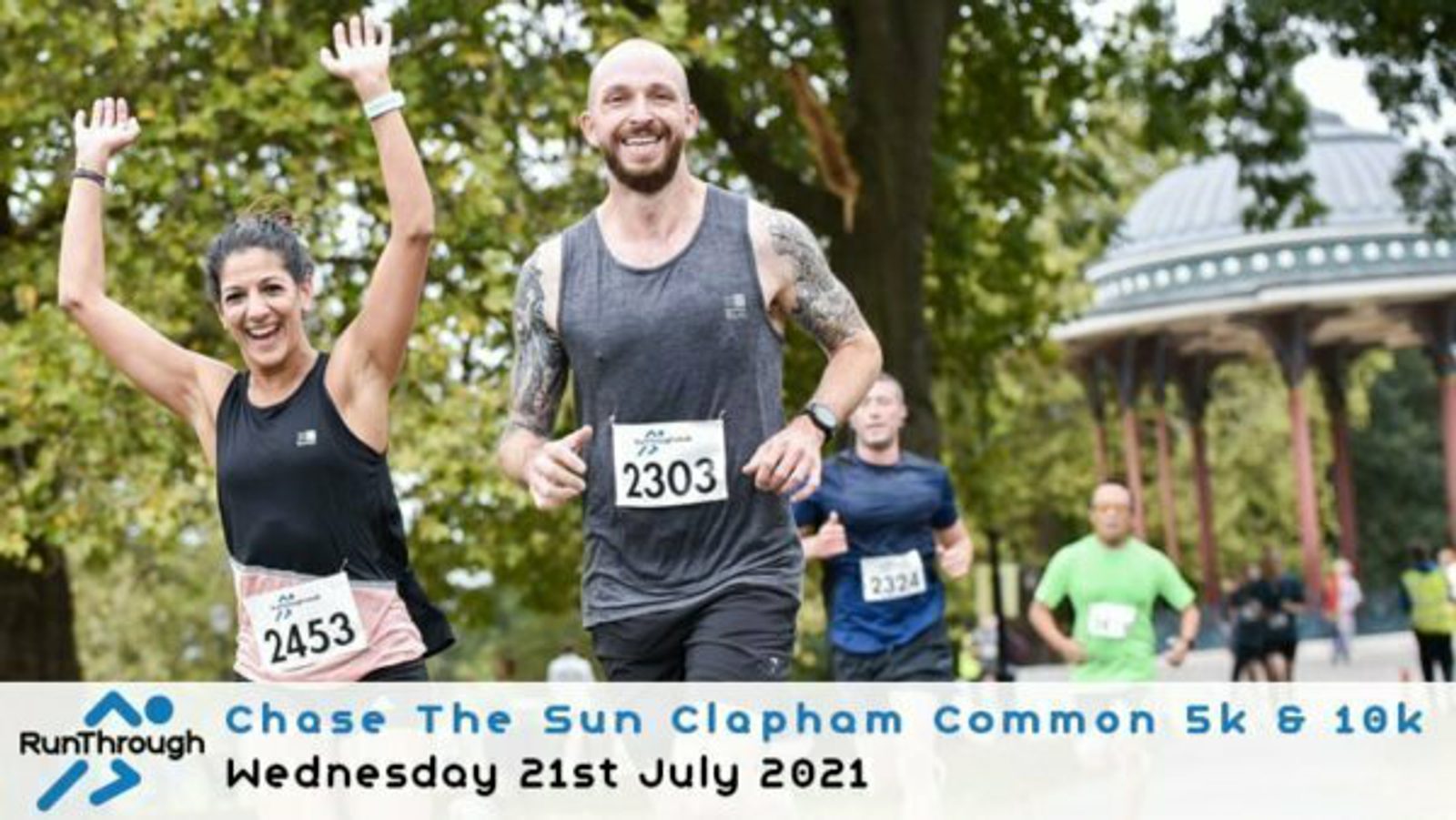 A group of runners participate in the Chase The Sun Clapham Common 5k & 10k event on Wednesday, 21st July 2021. The runners are smiling and energetic, with a gazebo and trees in the background. Two runners in front have bib numbers 2303 and 2453.