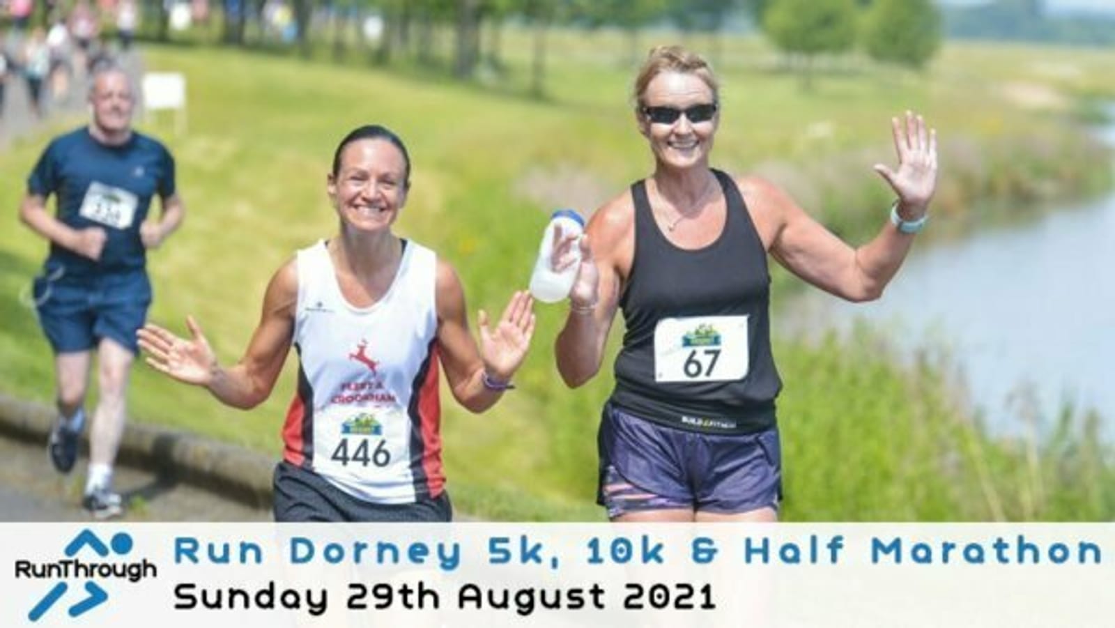 Two women smiling and waving as they run in a marathon event. One wears a white tank top with the number 446 and the other a black tank top with the number 67. The event text reads, "Run Dorney 5k, 10k & Half Marathon, Sunday 29th August 2021.