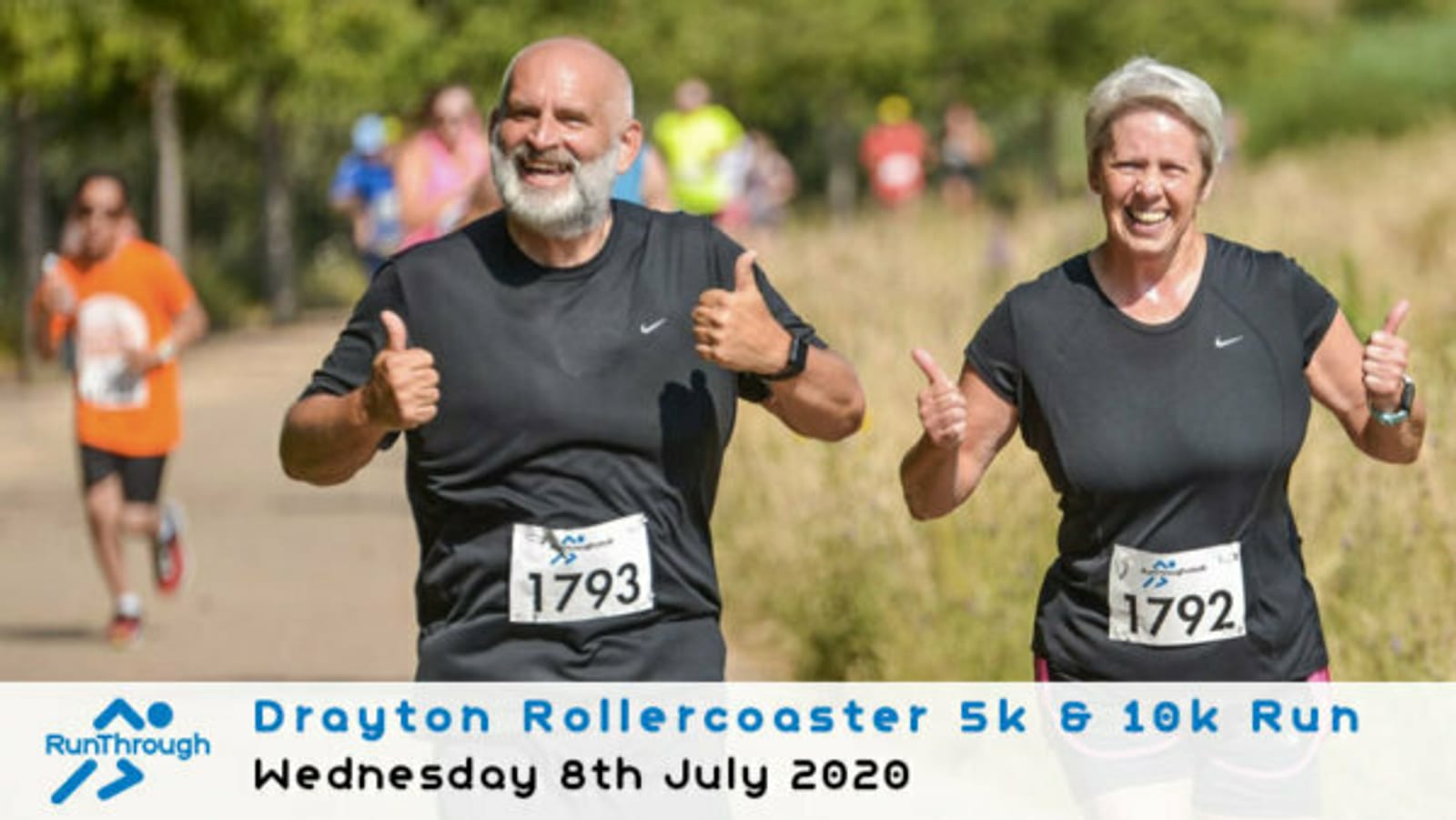 A man and a woman, both smiling and giving thumbs up, are running in an outdoor event. They are wearing numbered bibs, 1793 and 1792 respectively. Other runners can be seen in the background. The banner reads "Drayton Rollercoaster 5k & 10k Run" with the date "Wednesday 8th July 2020.