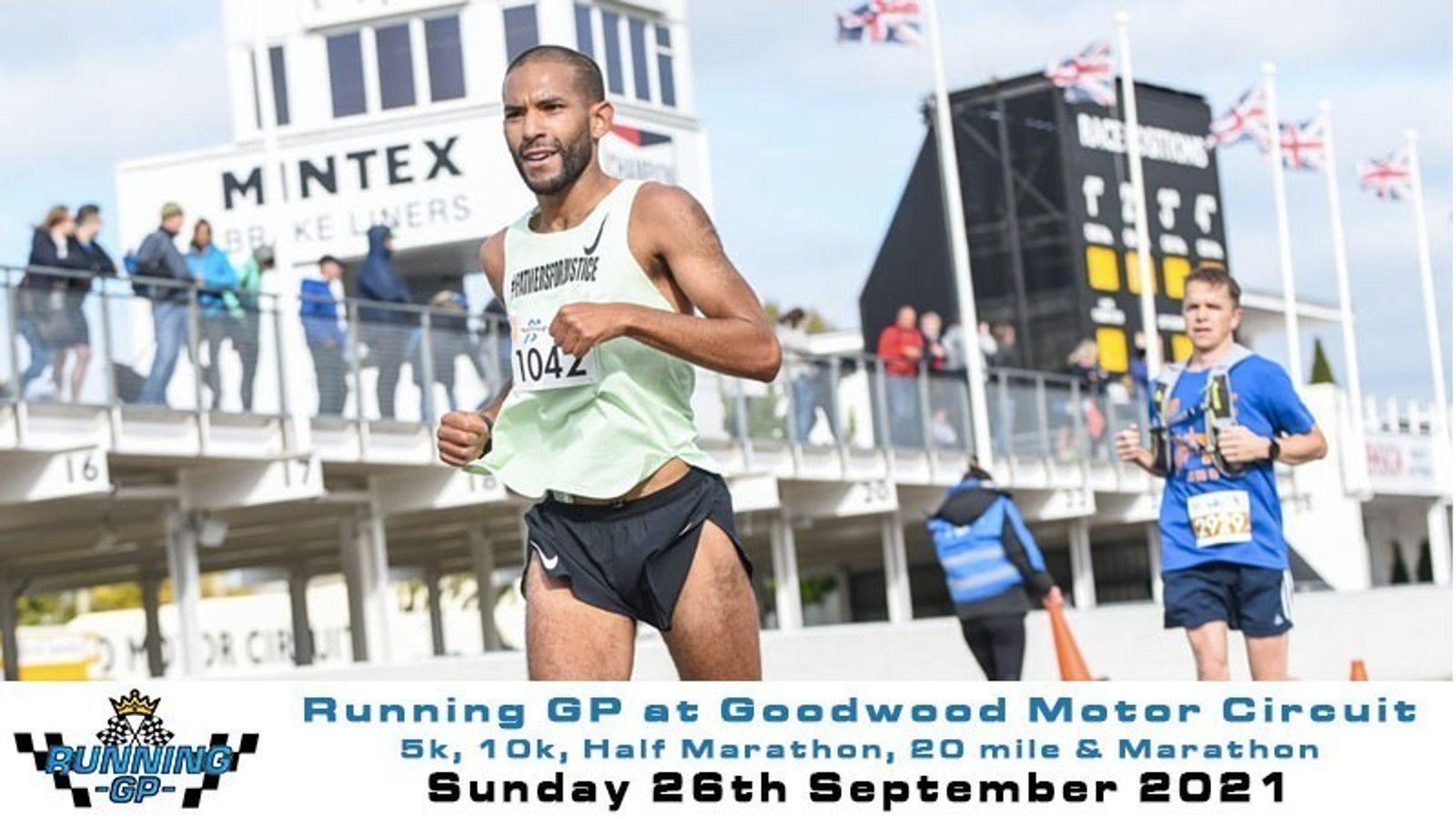 A runner in a light green tank top and black shorts with bib number 1042 participates in a race at Goodwood Motor Circuit. Other runners and spectators are visible, along with signage and flags in the background. Event details indicate multiple race distances on September 26, 2021.