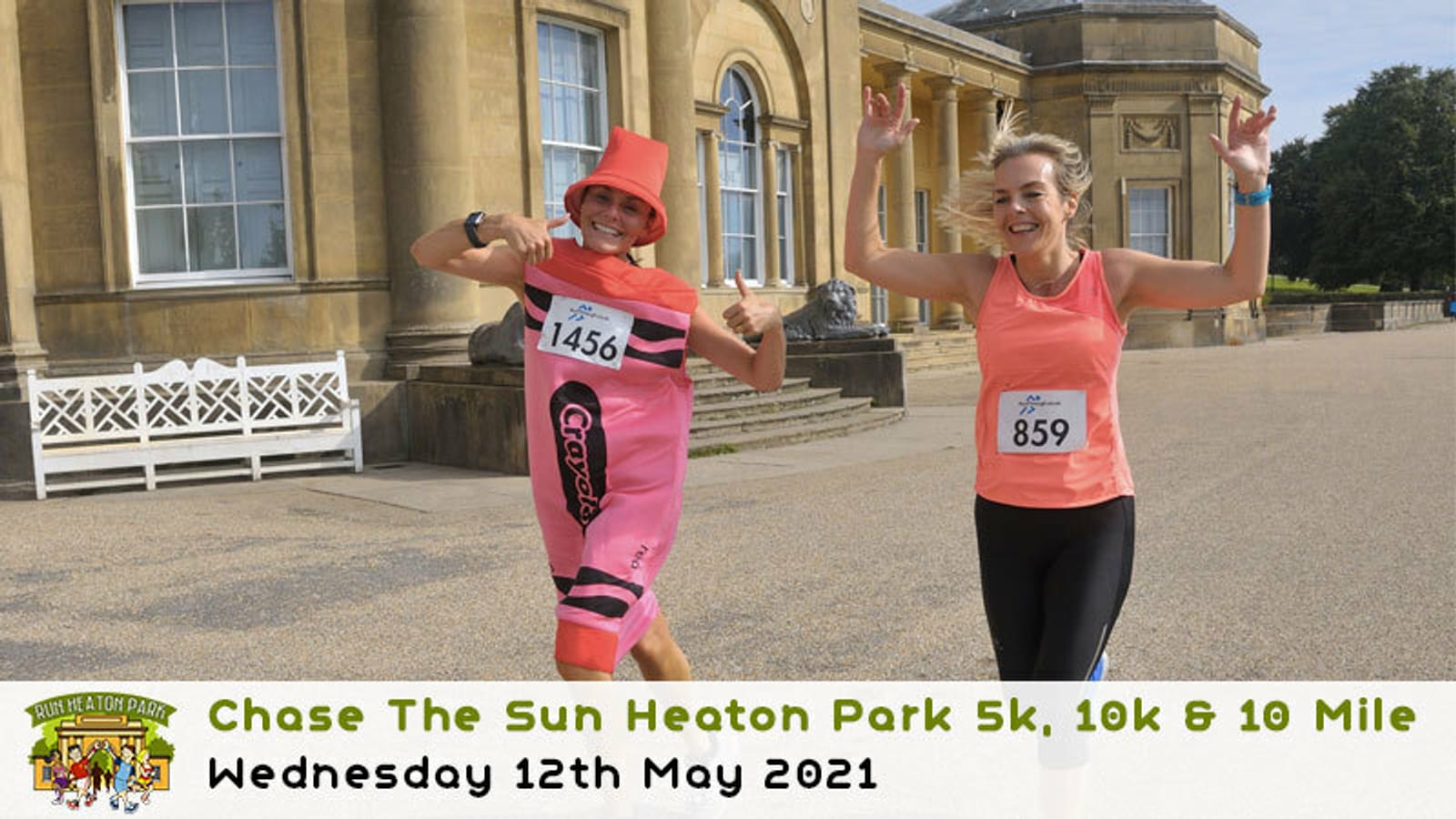 Two women are running in a race outside a large building. One wears a pink costume, and they both smile and gesture energetically. Race bibs read "1456" and "859." Below, text reads: "Chase The Sun Heaton Park 5k, 10k & 10 Mile, Wednesday 12th May 2021.