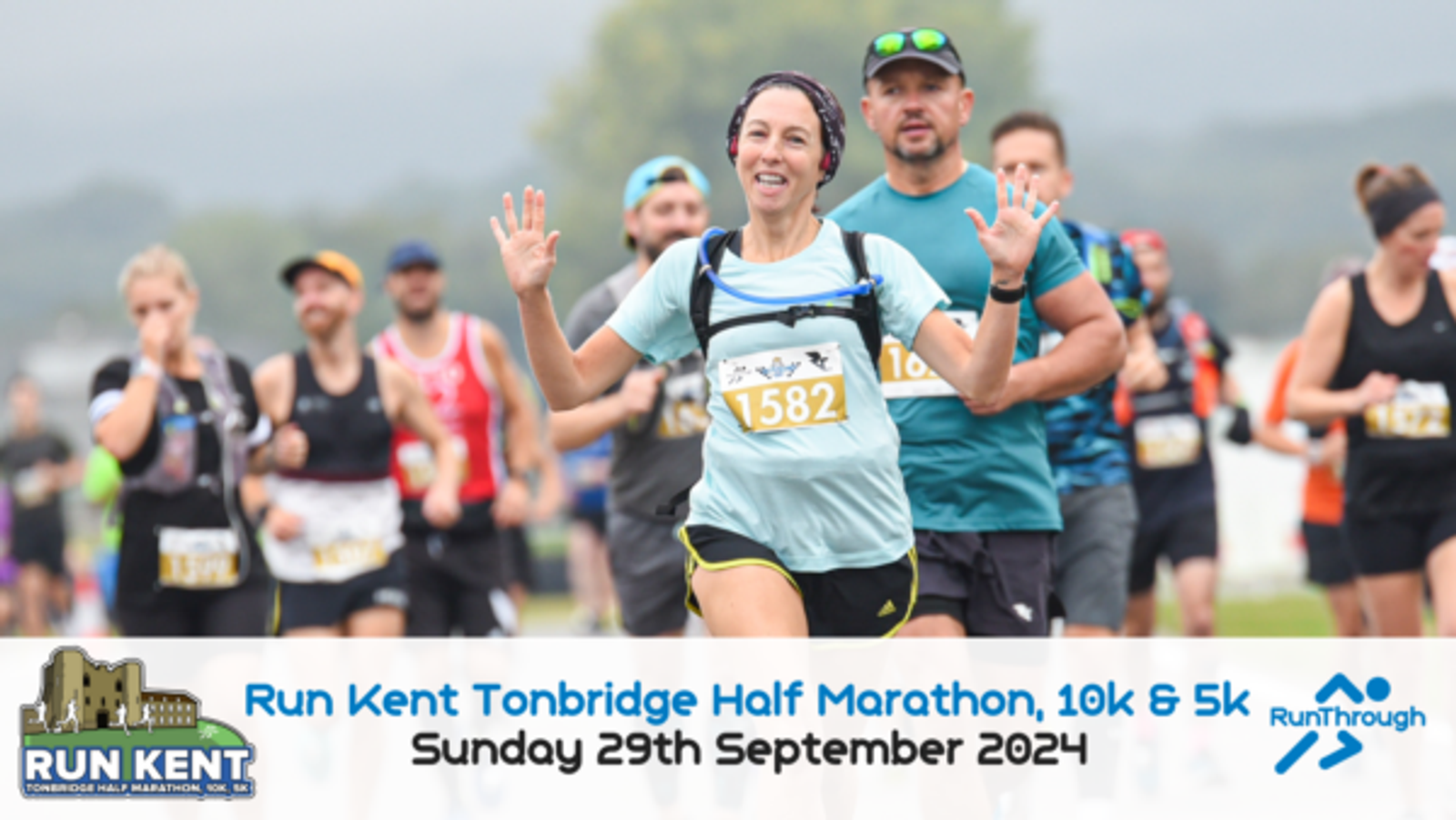 A group of runners participating in the Run Kent Tonbridge Half Marathon, 10k, and 5k event. A woman in a blue shirt and black shorts, wearing a race bib number 1582, is smiling and raising her hands. The event is scheduled for Sunday, 29th September 2024.