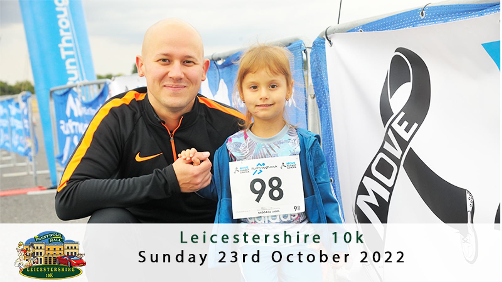 A man crouches next to a young girl who is wearing a race bib with the number 98. They are both smiling at the camera. Behind them is a banner with the words "Leicestershire 10k" and the date Sunday, 23rd October 2022 printed. A ribbon design with the word "MOVE" is also visible.