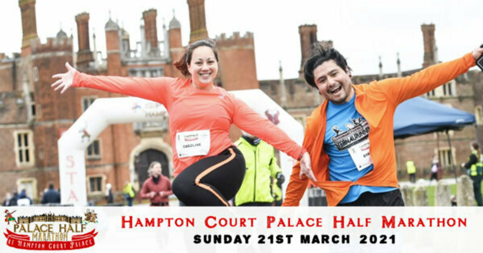 Two cheerful runners with race numbers 257 (left) and 263 (right) pose triumphantly near the finish line of the Hampton Court Palace Half Marathon, with Hampton Court Palace in the background. The event date is Sunday, 21st March 2021.