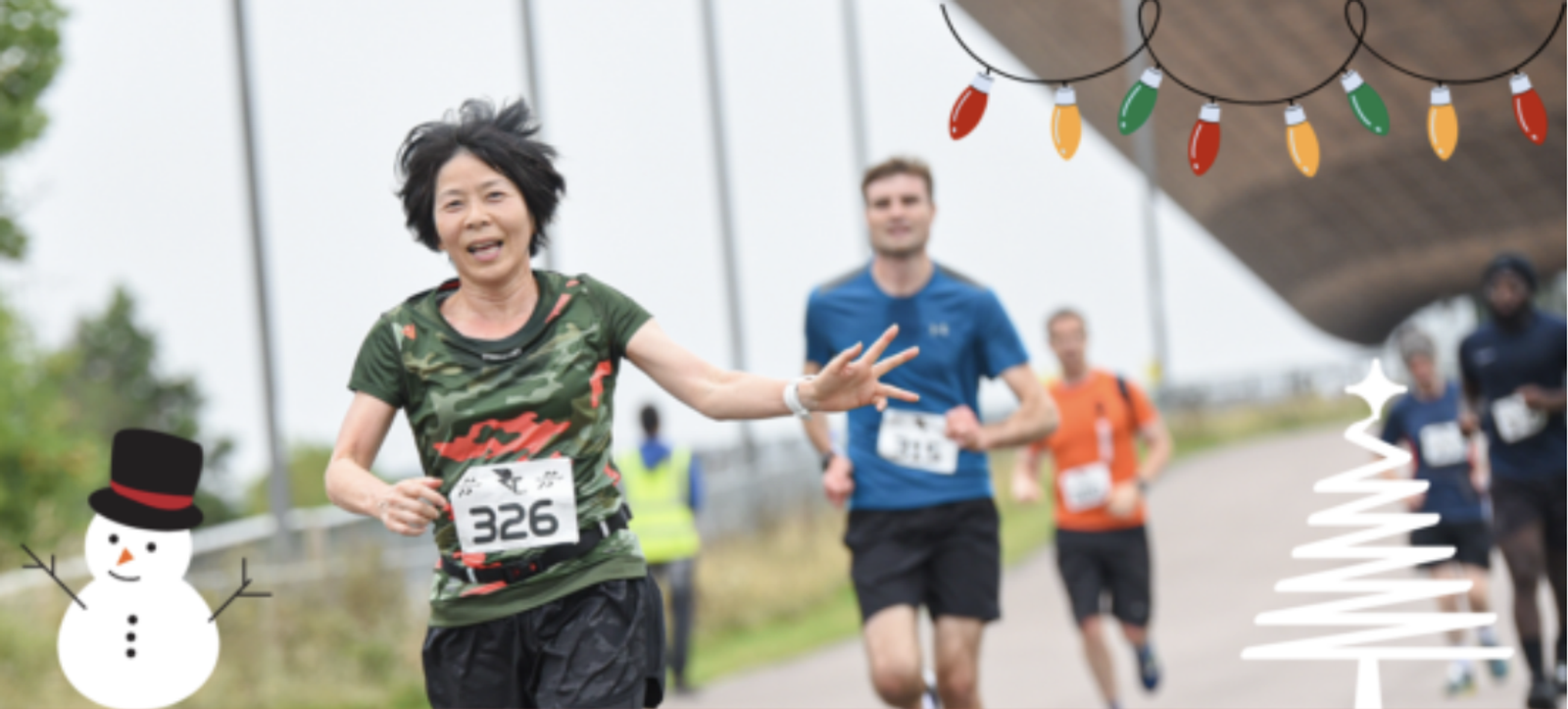 A woman with bib number 326 is running in a race, smiling and reaching out her hand. Behind her, other runners are also participating. The image is decorated with festive holiday graphics, including a snowman, a Christmas tree, and colorful string lights.