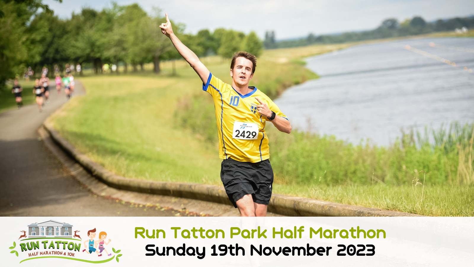 A runner wearing a yellow and blue jersey, numbered 2429, is seen mid-stride along a scenic path beside a body of water, raising his left arm in celebration. Other runners are in the background. Text at the bottom reads: "Run Tatton Park Half Marathon Sunday 19th November 2023.