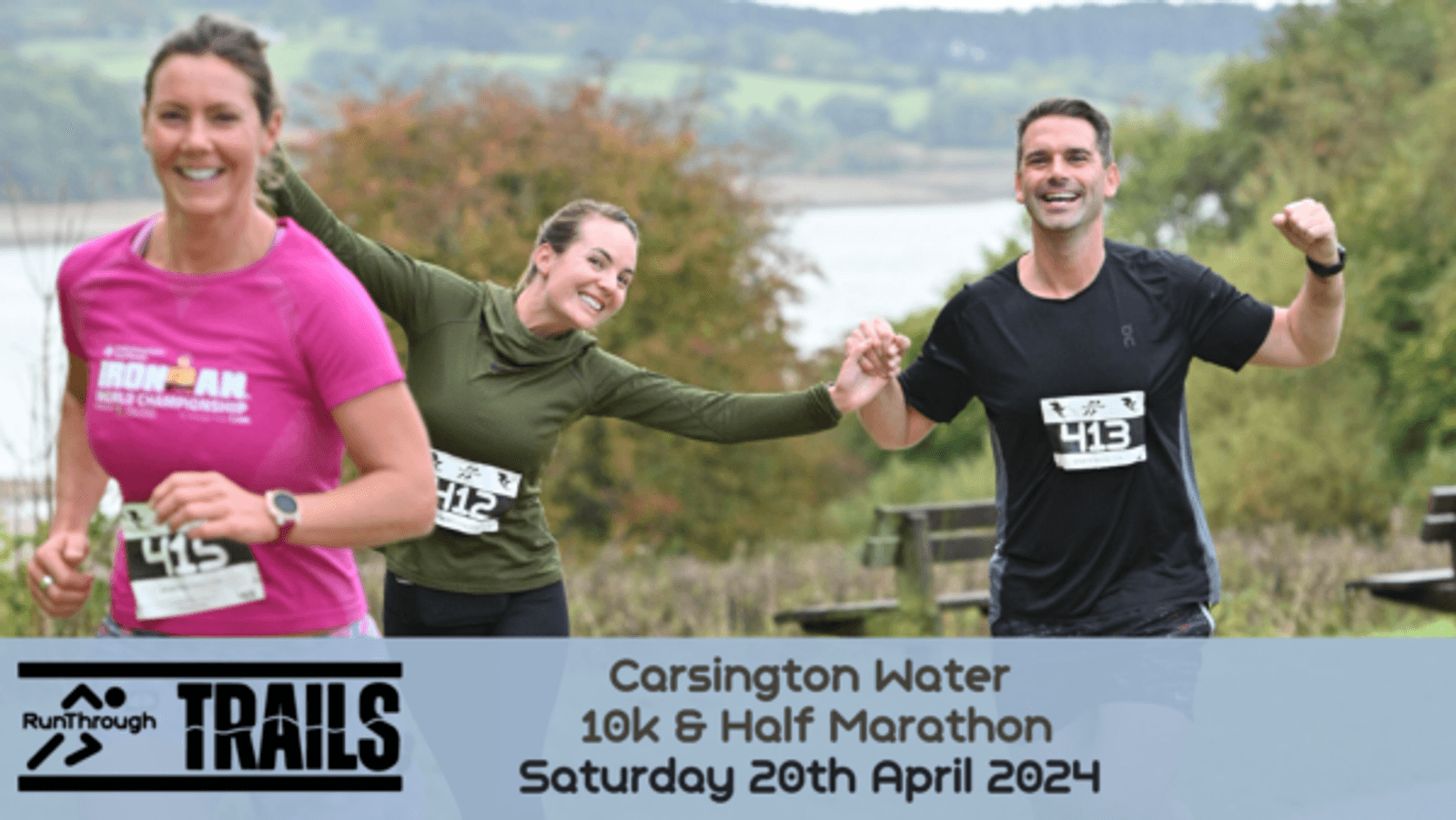 Three enthusiastic runners are smiling and celebrating as they participate in a race. They are wearing race bibs with the number 413. A scenic landscape with water and hills is in the background. The text overlay reads: "Carsington Water 10k & Half Marathon, Saturday 20th April 2024.