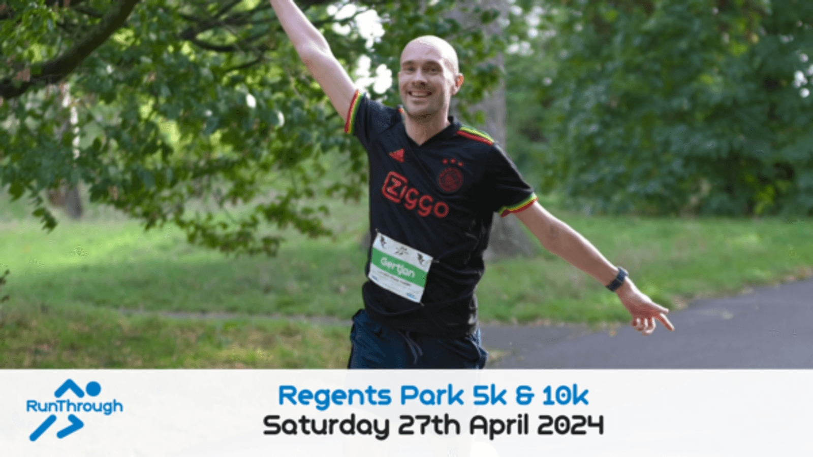 A man is running in a park during a 5k & 10k event, smiling with his arms raised in a celebratory pose. He's wearing a black sports shirt with "Ziggo" on it and a race bib. The event information reads "Regents Park 5k & 10k, Saturday 27th April 2024," with the RunThrough logo.