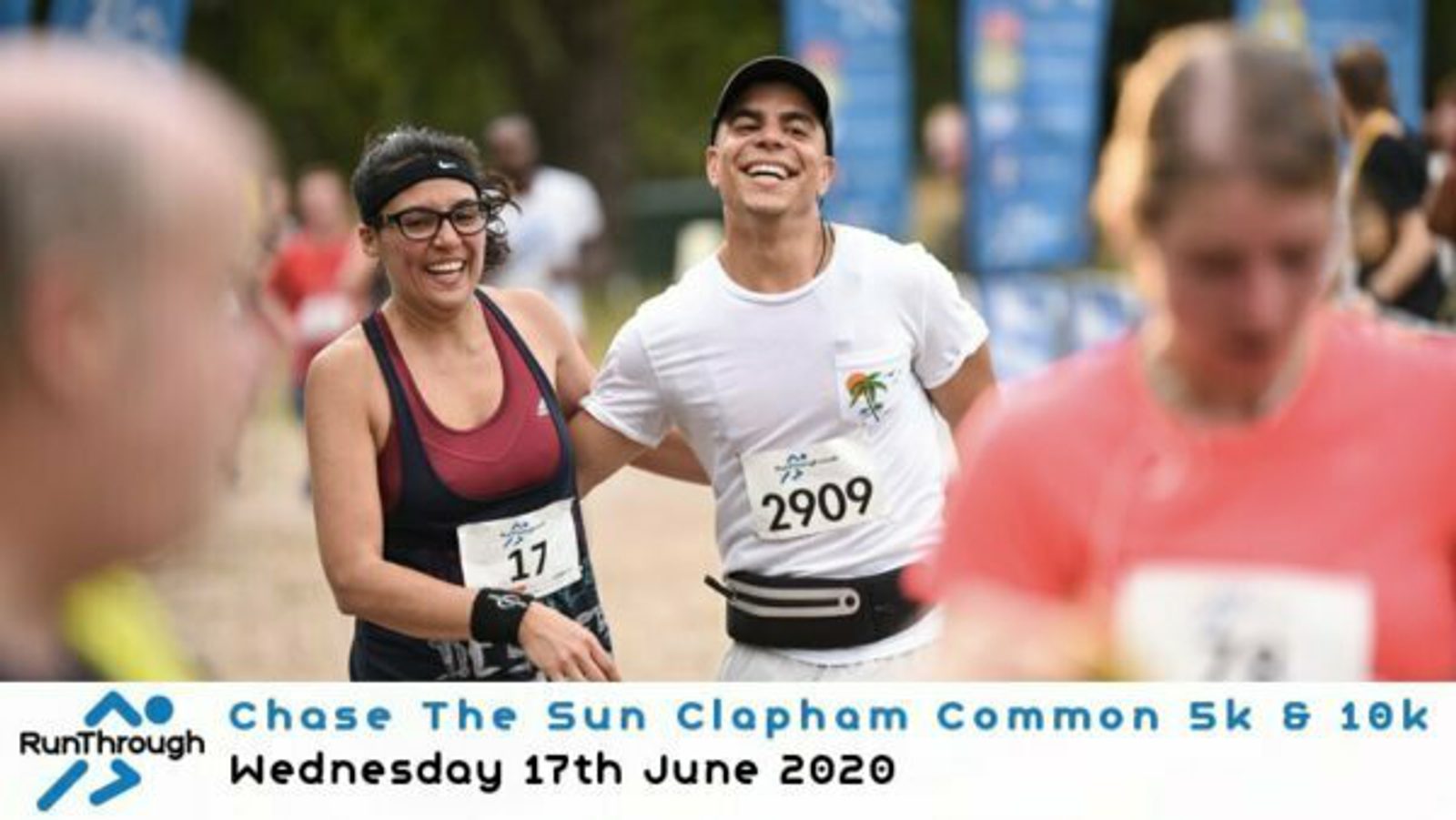 Two smiling runners, one wearing bib number 17 and the other 2909, are participating in an outdoor race. There are other participants blurred in the foreground and background. Text overlay at the bottom reads: "Chase The Sun Clapham Common 5k & 10k, Wednesday 17th June 2020.