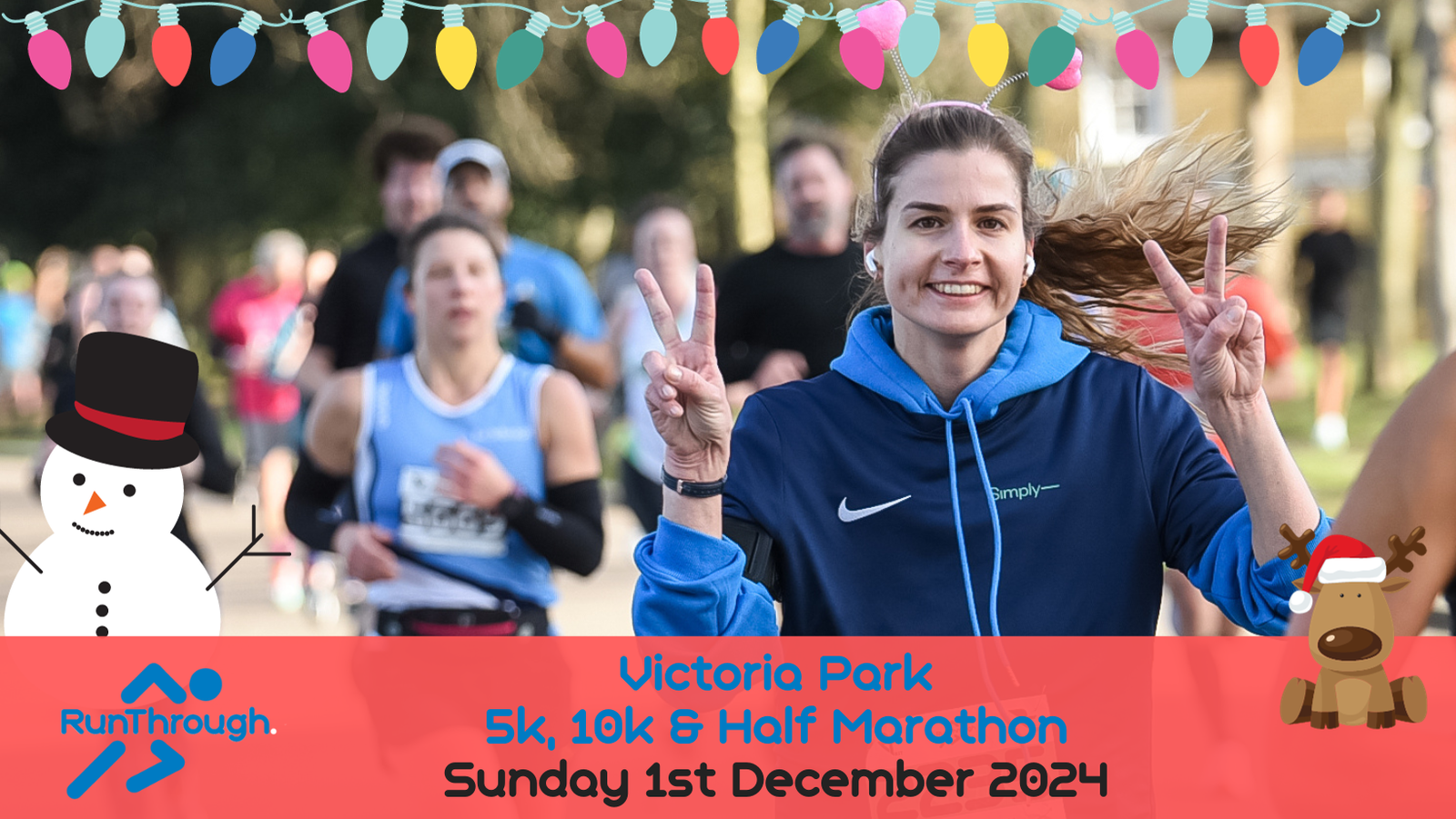 A smiling woman in a blue hoodie flashes peace signs while running in a marathon at Victoria Park. Other runners can be seen in the background. The image is decorated with festive lights and features a snowman and reindeer graphic. Event details: 5k, 10k, Half Marathon, Sunday 1st December 2024.