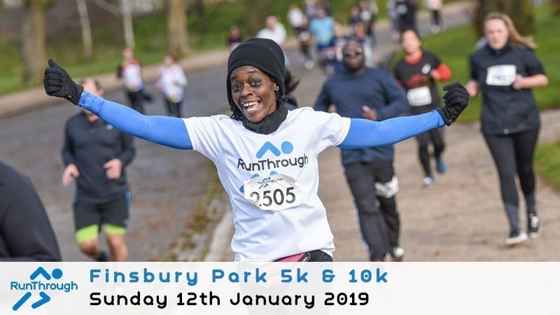 A joyful runner in a RunThrough t-shirt spreads her arms wide during a 5k and 10k event at Finsbury Park. Other participants run in the background. The event date is Sunday, 12th January 2019.