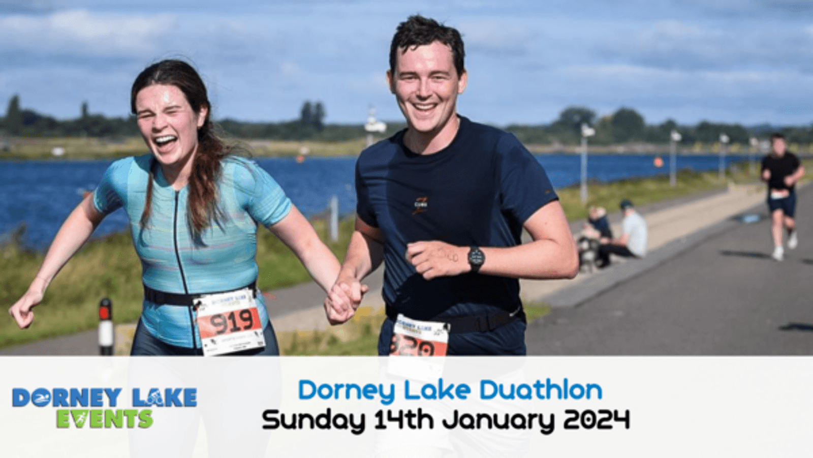 Two runners are smiling and holding hands while running during the Dorney Lake Duathlon. They are dressed in athletic wear. The event date, "Sunday 14th January 2024," is displayed at the bottom of the image. Other participants are visible in the background.