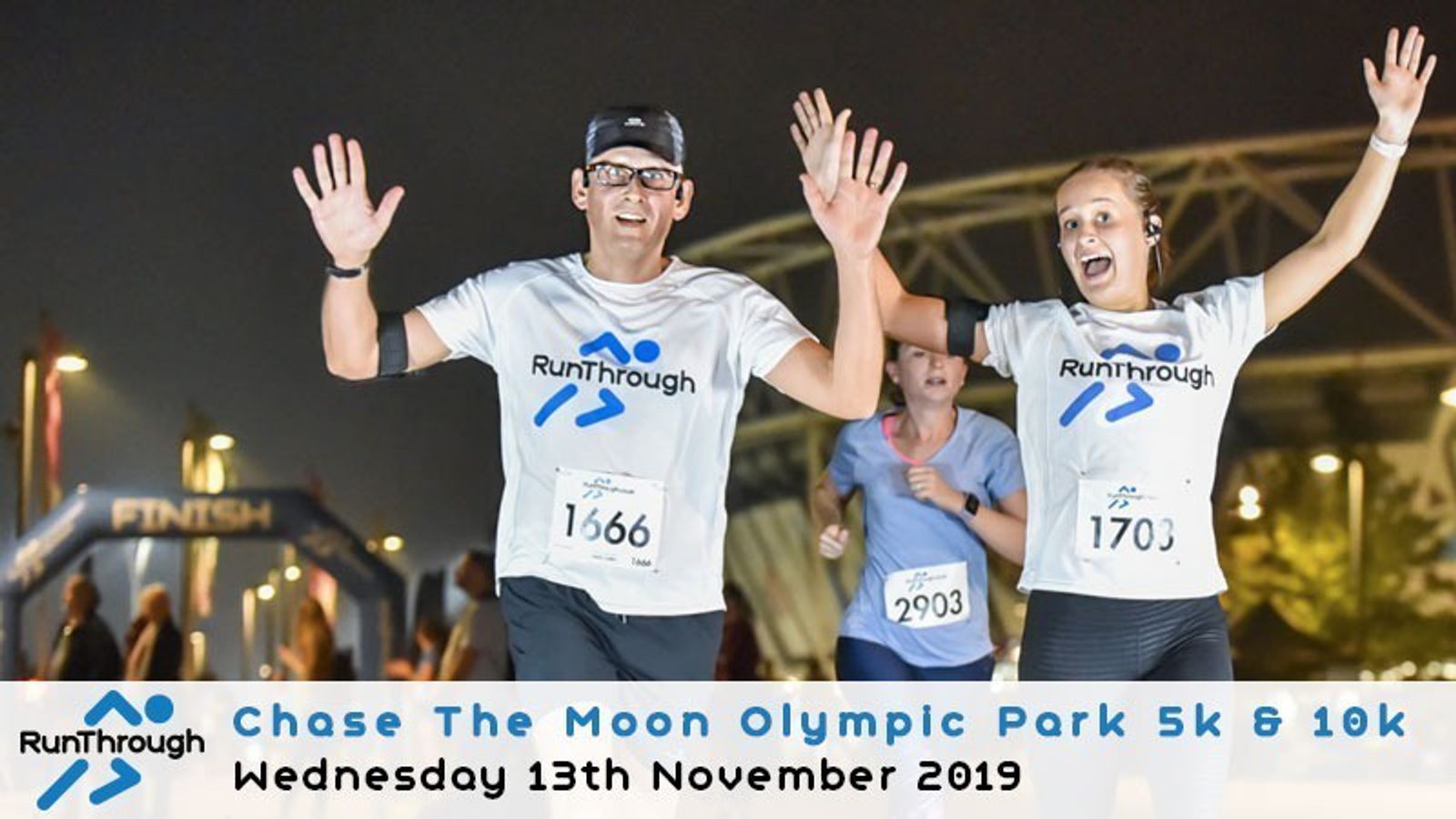 Runners approach the finish line during the 'Chase The Moon Olympic Park 5k & 10k' event on Wednesday, 13th November 2019. They wear white T-shirts with the RunThrough logo. Both smile as they near the end, with race bibs 1666 and 1703 visible.