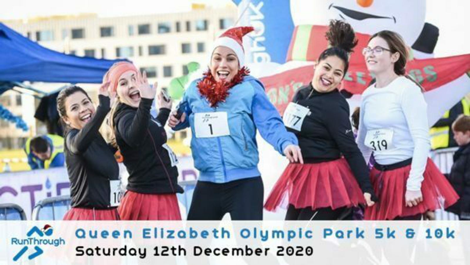 A group of people dressed in festive costumes pose cheerfully at the Queen Elizabeth Olympic Park 5k & 10k event. They wear Santa hats, tutus, and reindeer antlers. The event details are displayed at the bottom, indicating it took place on Saturday, 12th December 2020.