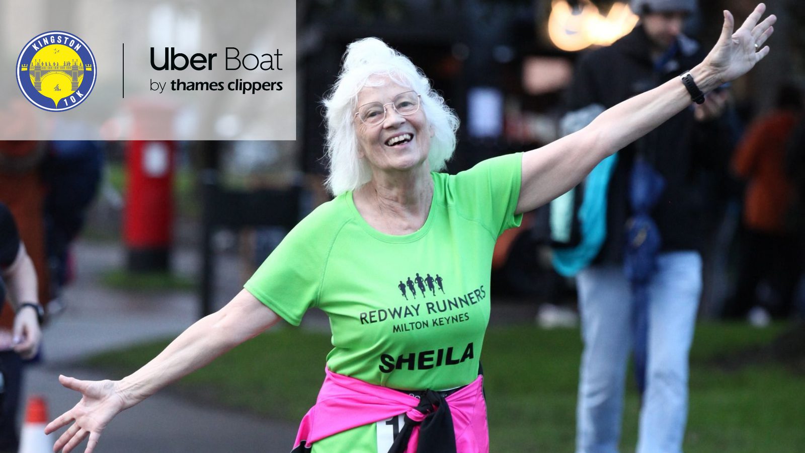 A smiling elderly woman named Sheila is wearing a neon green “Redway Runners” shirt with her arms outstretched. She is outside with a grass background and a few people in the distance. The image features the logos of Kingston BID and Uber Boat by Thames Clippers.