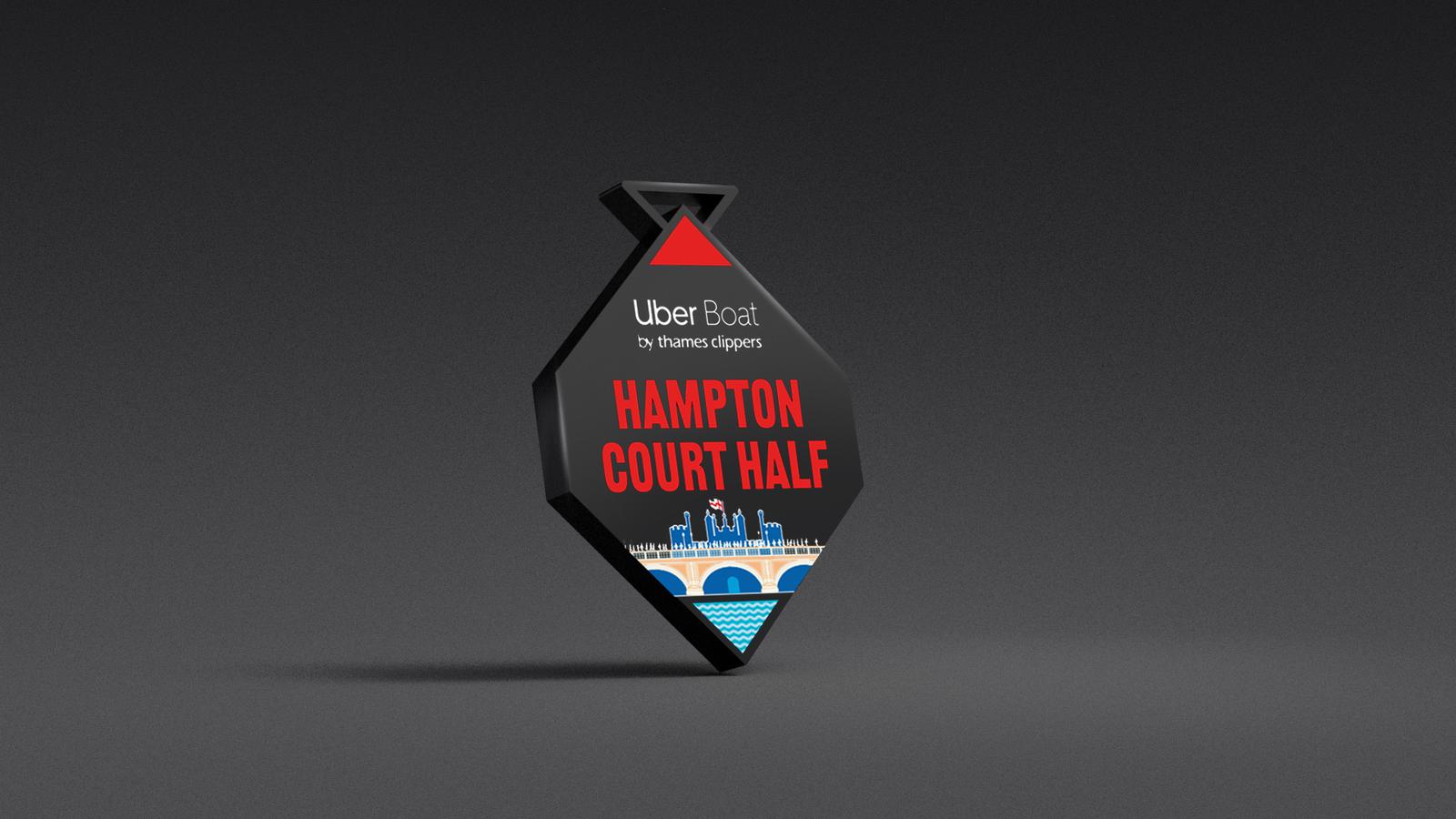 Diamond-shaped medal with "Uber Boat by Thames Clippers" at the top, "Hampton Court Half" in bold red text in the center, and an illustration of Hampton Court Palace with a river at the bottom, set against a dark background.