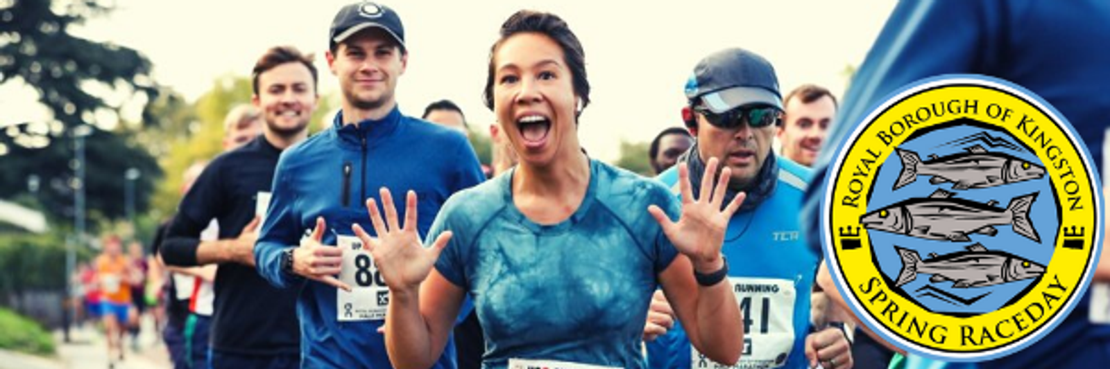 A group of enthusiastic runners participating in a race, with some wearing numbered bibs. A woman in front is smiling broadly with her hands raised in excitement. The "Royal Borough of Kingston Spring Raceday" logo featuring fish and blue water is seen on the right.