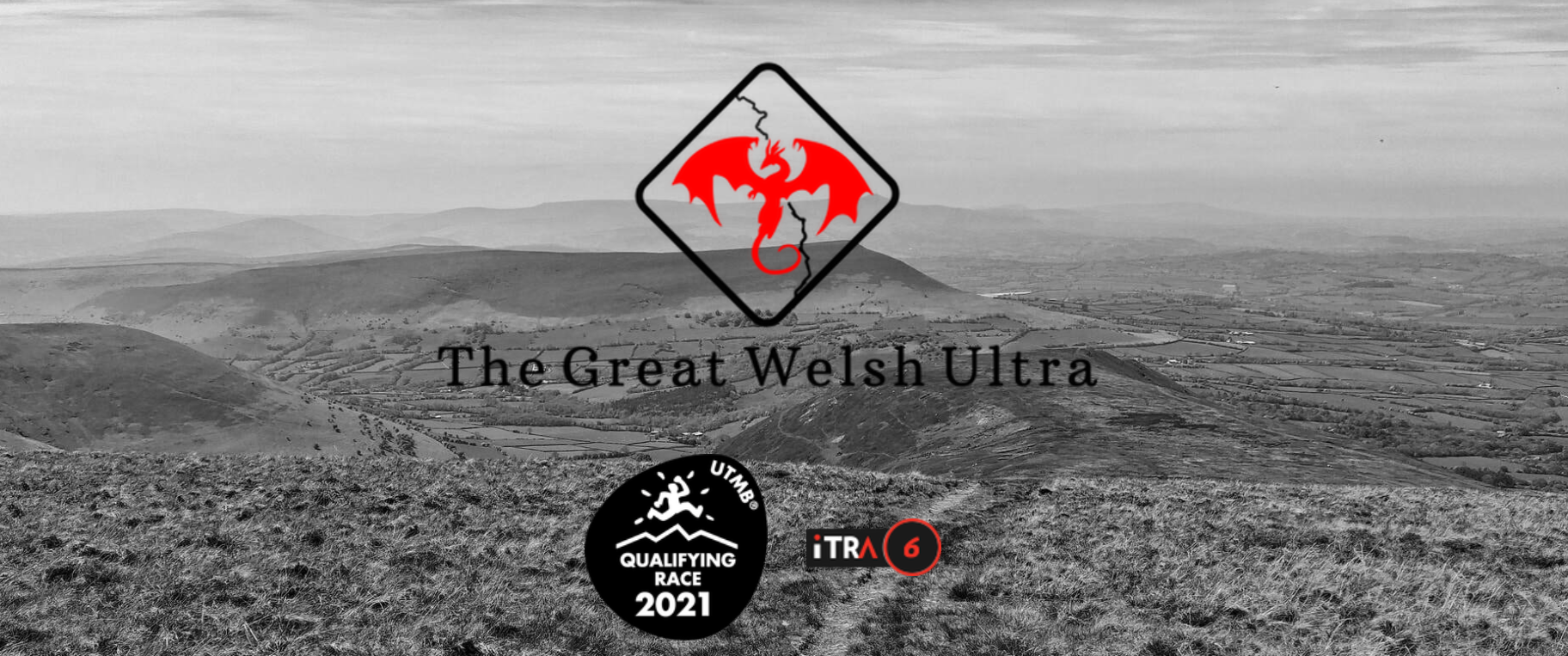 A black-and-white landscape photo shows rolling hills under a cloudy sky. The Great Welsh Ultra logo, featuring a red dragon inside a diamond shape, is centered. Two additional logos at the bottom represent a 2021 qualifying race and an iTRA rating of 6.