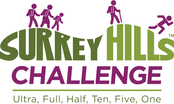 Logo for the Surrey Hills Challenge. It features stylized green hills with human figures walking on top, followed by the words "Surrey Hills" in green and "Challenge" in purple below. Underneath, it lists "Ultra, Full, Half, Ten, Five, One" in smaller green text.