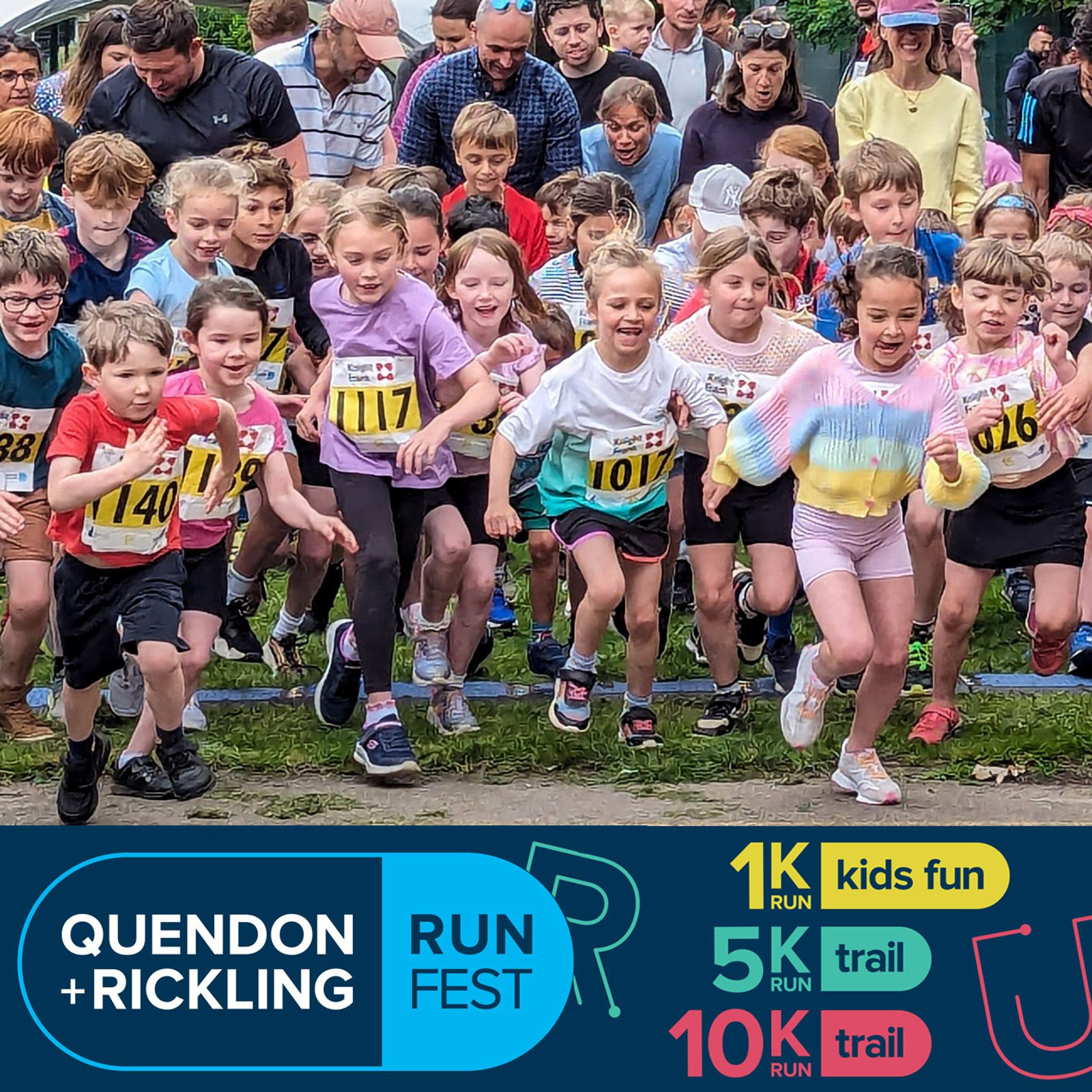 A group of enthusiastic children, wearing race numbers, start running at the Quendon + Rickling Run Fest. The crowd in the background cheers them on. The event sign indicates a kids fun run, a 5K trail run, and a 10K trail run.