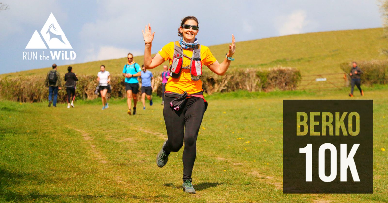 A smiling runner wearing a yellow shirt and a hydration vest is raising her hands in a celebratory gesture while running on a grassy trail. Other runners are seen in the background. The text on the image reads, "RUN the WILD" and "BERKO 10K.