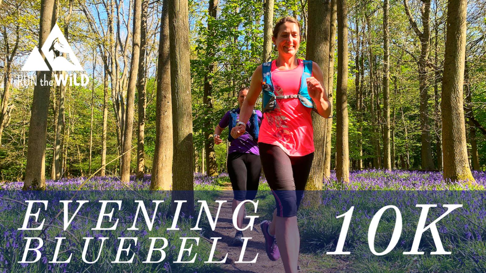Two women trail running through a forest with blooming bluebells. The runner in the foreground wears a bright pink top and black leggings, while the one behind wears a purple top and black leggings. Text overlay reads "EVENING BLUEBELL 10K" and "RUN the WILD.