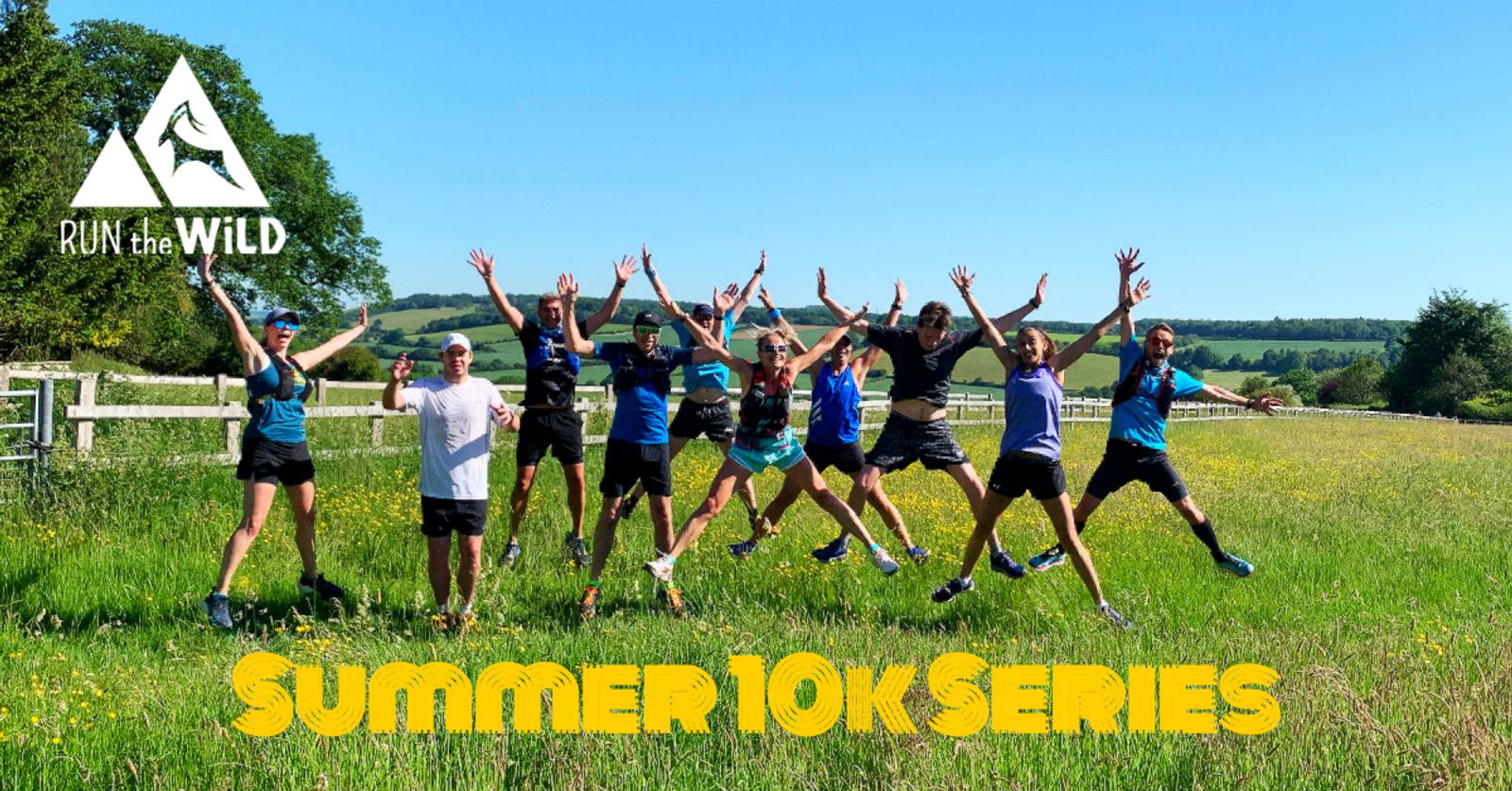 A group of people is mid-jump with arms raised, standing on a grassy field under a clear blue sky. They are wearing activewear, and a fence and trees are in the background. Text reads "RUN the WILD" with a logo on the top left and "SUMMER 10K Series" at the bottom.