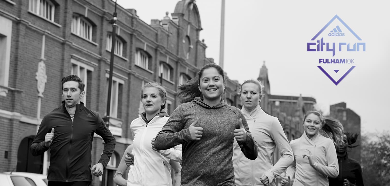 A group of people jogging on a city street, with historic buildings in the background. The image is in black and white and features a "City Run Fulham" logo in the upper right corner.
