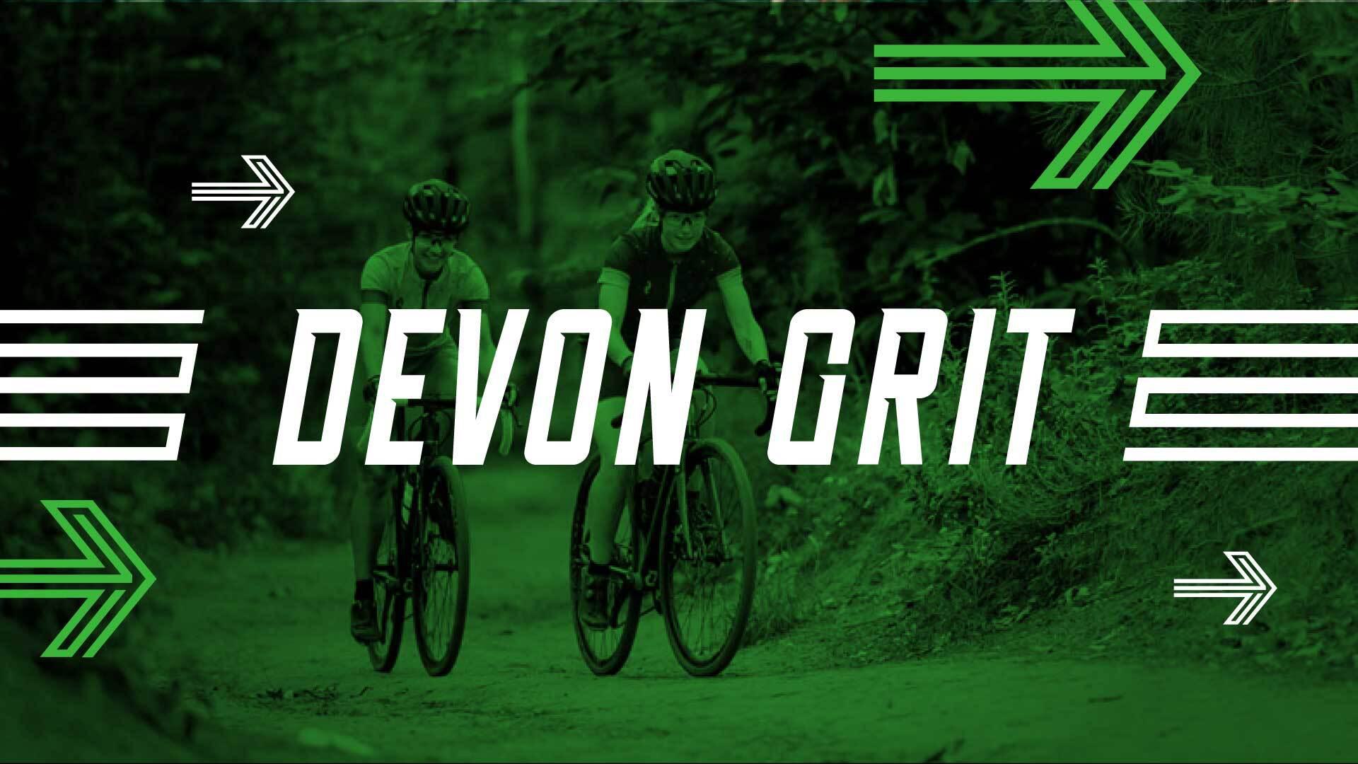 Two cyclists ride on a forest path, surrounded by greenery. The text "Devon Grit" is prominently displayed in bold white letters. Arrows point to the right, emphasizing motion and direction. The image is tinted green.