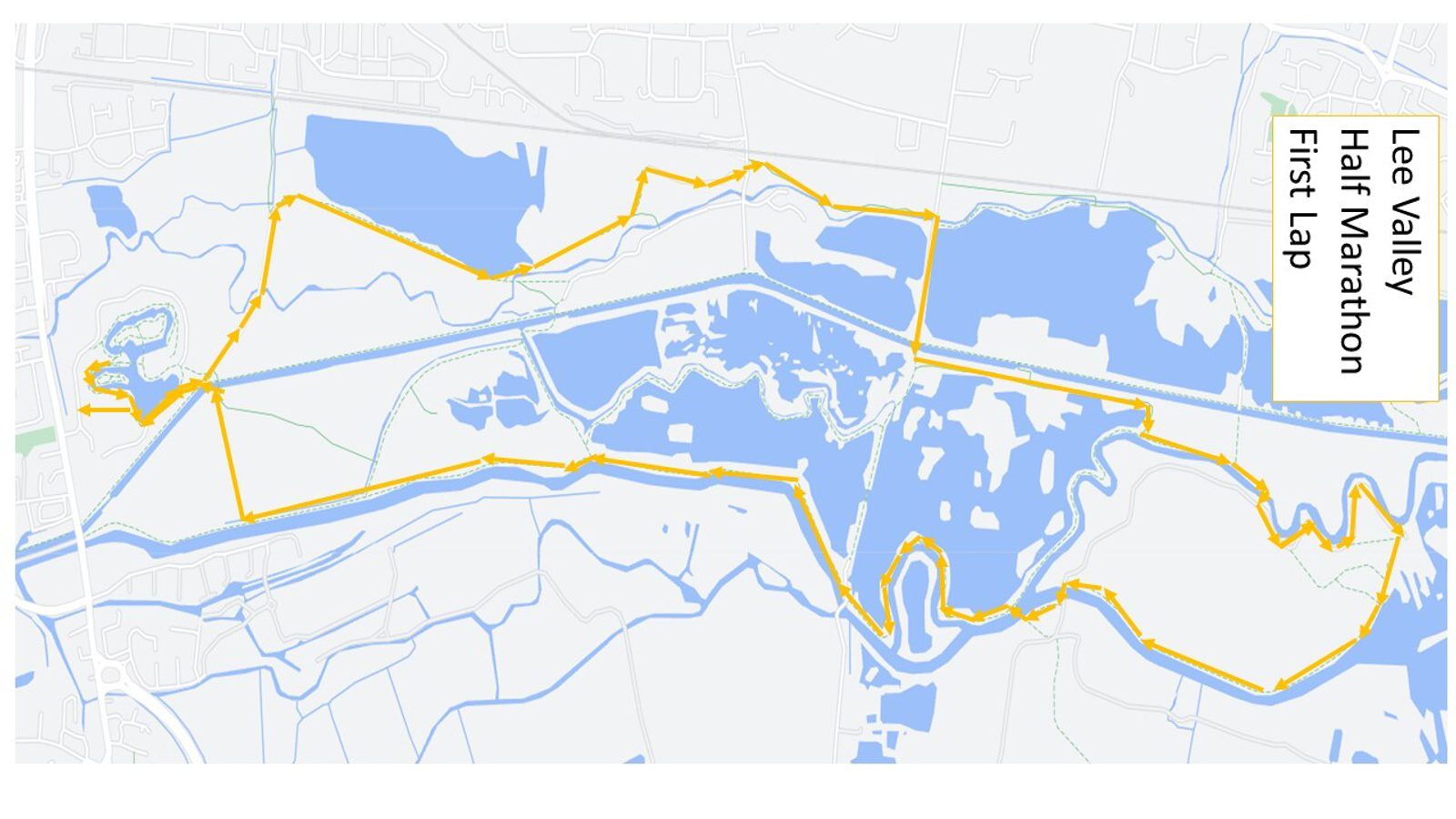 A map showing the route of the Lee Valley Half Marathon first lap, marked by a bold yellow line. The route weaves through various landscapes, including water bodies and park areas, forming an intricate path spanning across the map.