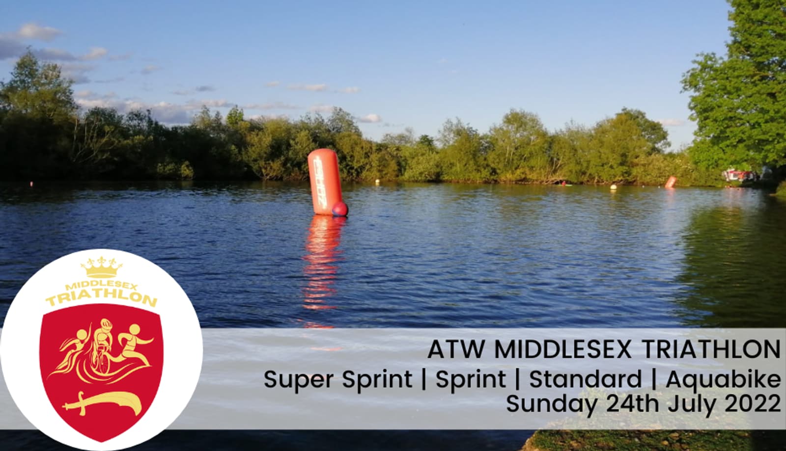 A serene lake setting with a red buoy marking the course for a triathlon event. Trees line the horizon under a blue sky. An overlay text reads "ATW Middlesex Triathlon, Super Sprint | Sprint | Standard | Aquabike, Sunday 24th July 2022," along with a triathlon logo.